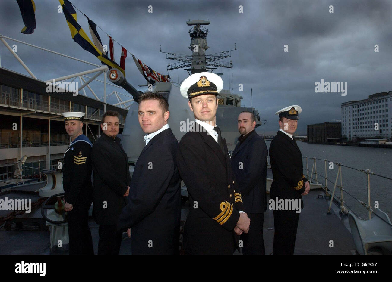 (Vordere Reihe, links - rechts) Schauspieler Alex Farns mit seinem realen Gegenstück Commander Alex Burton, (hintere Reihe, links - rechts) Hauptkoch Warren Dimond und Schauspieler Lee Boardman, Schauspieler Steven Kennedy mit seinem realen Gegenstück Lieutenant Commander Philip Nash während eines Fotoalles für das neue Carlton TV Drama Making Waves, Heute Mittwoch, 14. Januar 2004, an Bord der HMS Northumberland auf der Schroders International London Boat Show, Excel Center, London Docklands. Das Drama spiegelt das Leben und die Werke der Männer und Frauen in der Royal Navy wider, die an Bord einer fiktiven Navy-Fregatte spielt. PA Foto: Andy Stockfoto