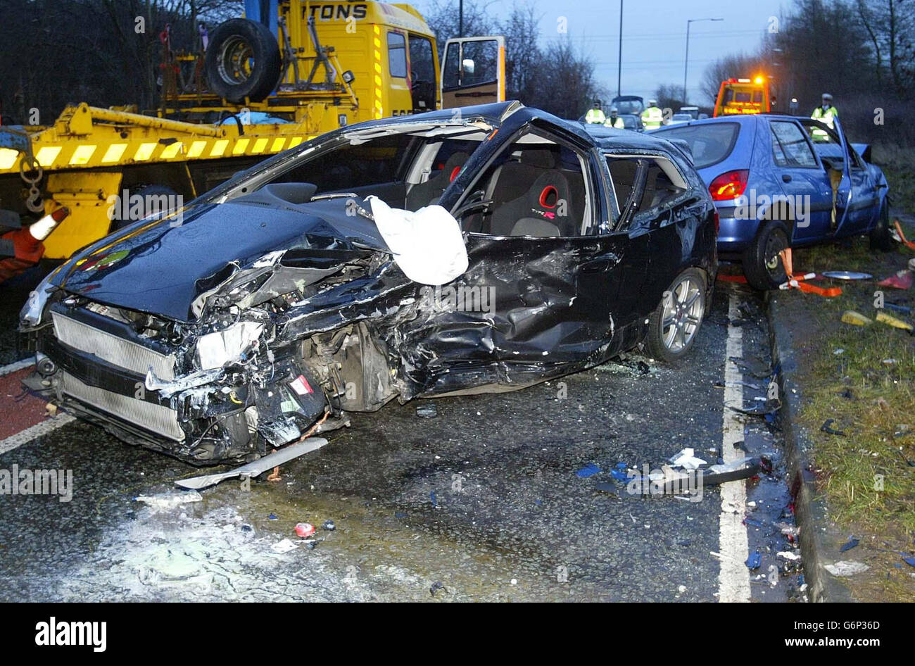 Das Wrack eines Unfalls, bei dem zwei Manchester United Youth Team Spieler verletzt wurden (schwarzes Auto) auf der Carrington Lane, Carrington, Manchester. Stockfoto