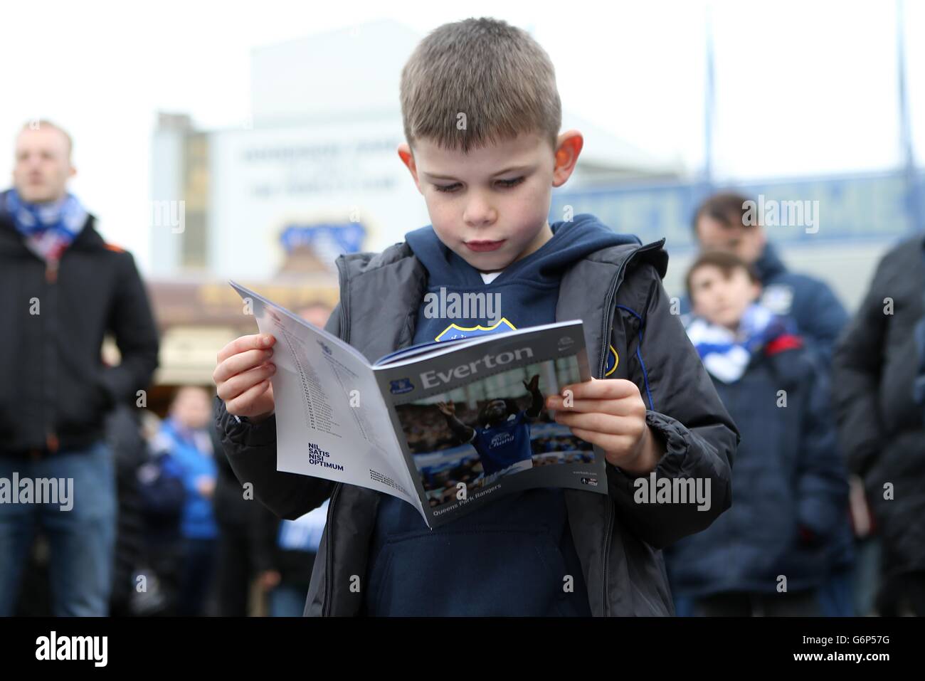 Ein junger Everton-Fan liest vor dem Spiel das Spieltag-Programm in der Fanzone Stockfoto