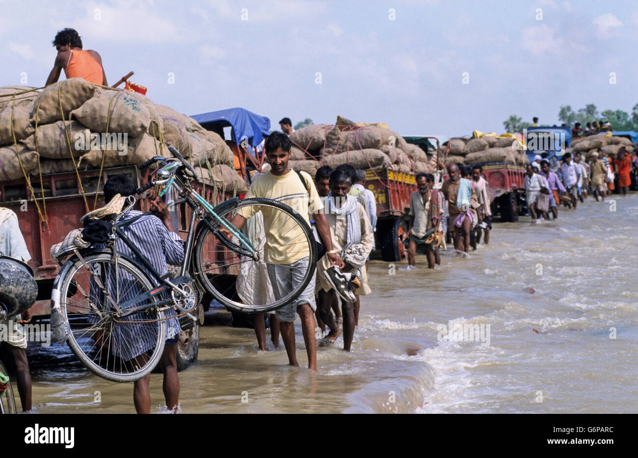 Indien, Bihar, Überflutung am Bagmati River ein Zweig der Ganges/Ganga Fluss wegen der schweren Monsunregen und schmelzen die Gletscher im Himalaya, Broken Bridge und beschädigte Straße, Menschen zu Fuß im Wasser, Traktor Transport von Nahrungsmitteln und Hilfsgütern - Folgen des Klimawandels und der globalen Erwärmung Auswirkungen Stockfoto