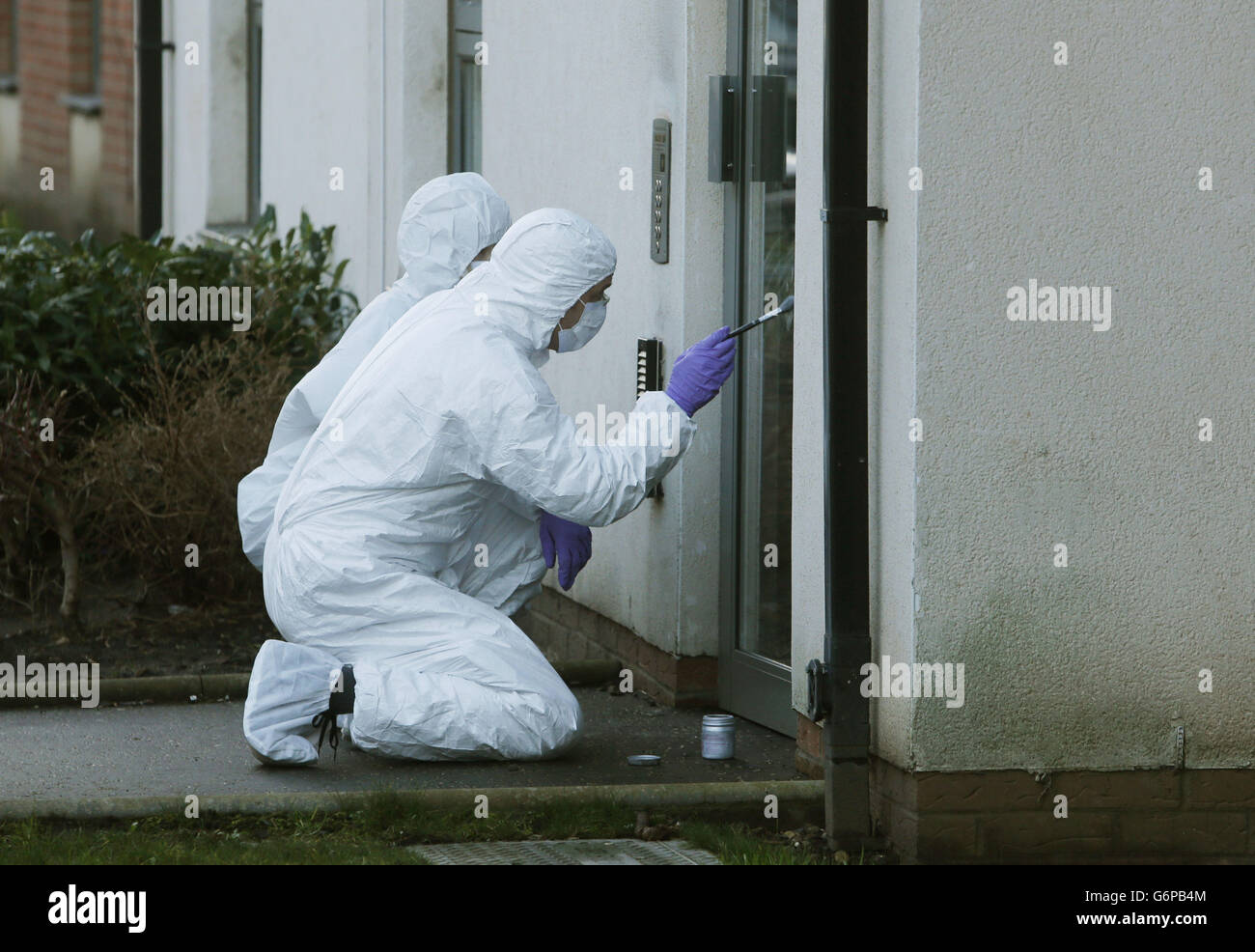 Polizeiforensische Beamte arbeiten an einer Eingangstür zu Wohnblocks in Ferry Gait Crescent, Edinburgh, da der dreijährige Mikaeel Kular aus seinem Haus verschwunden ist. Stockfoto