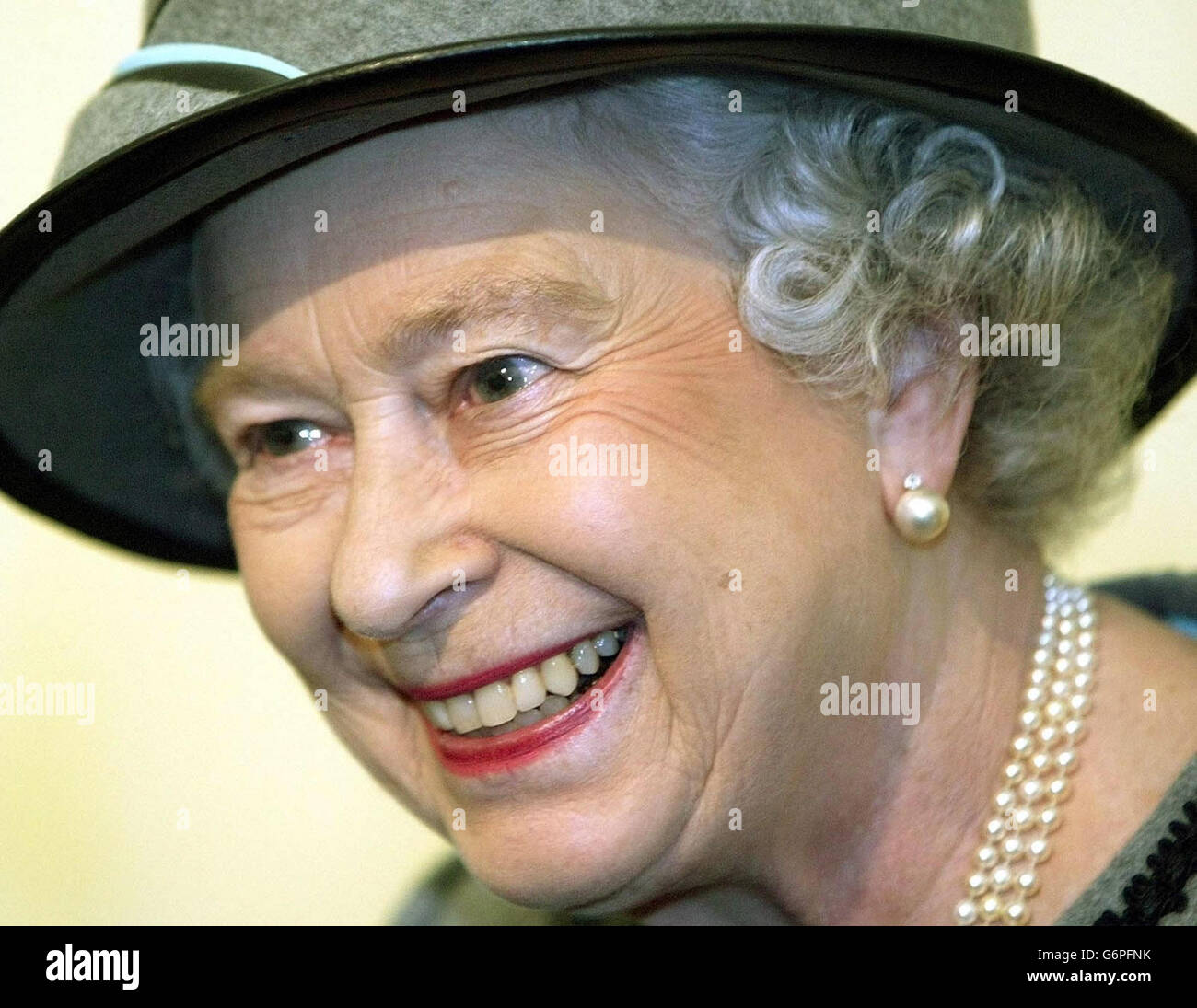 Die britische Königin Elizabeth II. Lächelt, als sie im Westen Londons eine neue Fabrik für Remploy eröffnet, die 84 Fabriken hat, in denen behinderte Menschen in ganz Großbritannien beschäftigt sind. Zu den vielfältigen Produkten, die in der Fabrik hergestellt werden, gehören CD-Hüllen und Atemschutzgeräte für das US-Militär. Als die Queen die Werkmontage besuchte, wurde ihr gezeigt, wie ein Coldplay-Album verpackt ist. Stockfoto