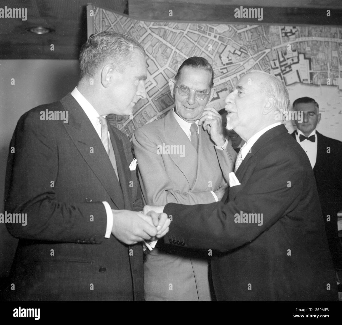 Sir Thomas Beecham, der Dirigent, grüßt Norman Collins, die Persönlichkeit des kommerziellen Fernsehens (l) beim Second International Celebrity Luncheon in der Royal Festival Hall, London. Das Zentrum ist Neville Cardus. Stockfoto