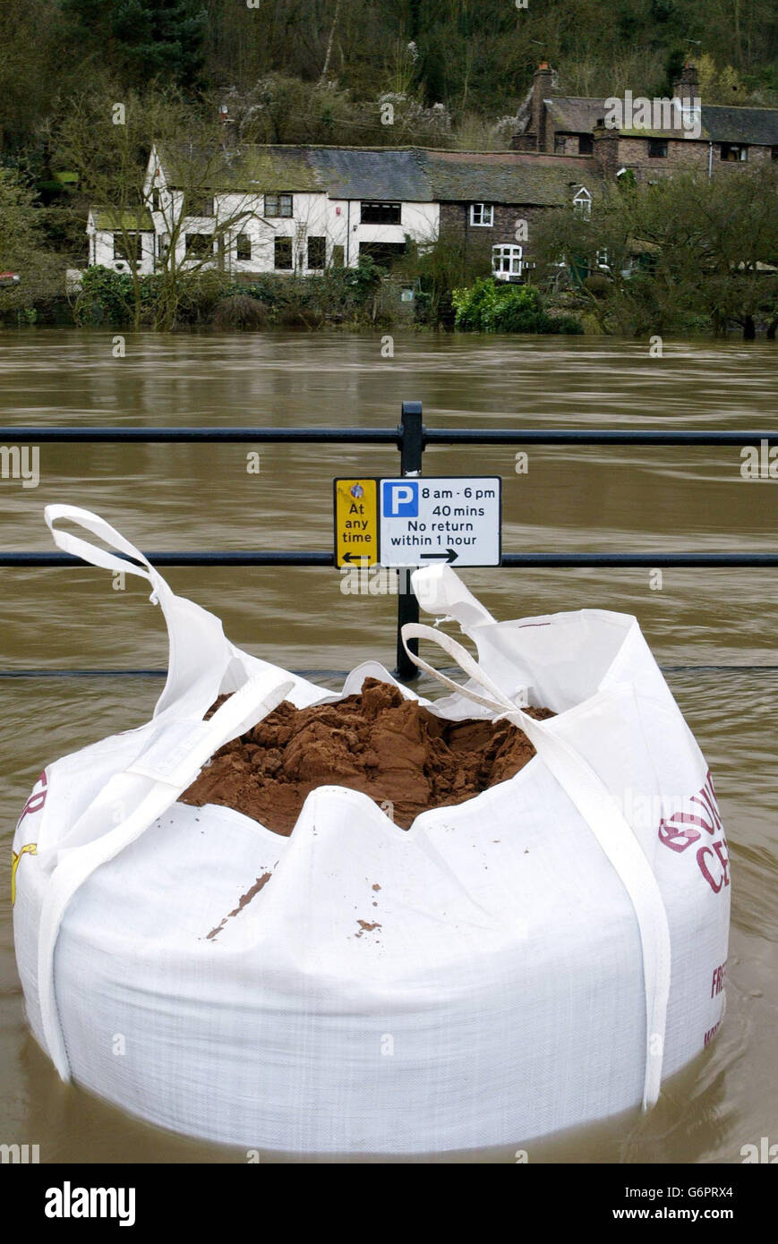 Mit dem Anstieg des Wasserspiegels auf dem Fluss Severn wurden Sandsäcke aufgestellt, um die vorübergehenden Hochwasserschutzbarrieren auf dem Wharfage in Ironbridge in der Nähe von Telford, Shropshire, abzuhalten, wobei Gärten bereits überflutet sind, die Bewohner hoffen, dass die Barrieren Überschwemmungen in ihren Häusern verhindern werden. Tausende von Eigenheimbesitzern könnten für Überschwemmungen und Senkungen Schäden an ihren Sachversicherungen geltend machen. Stockfoto