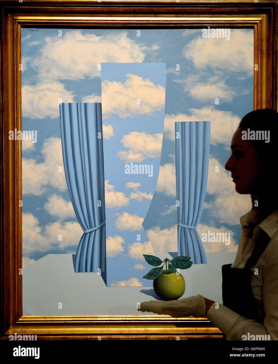 Eine Mitarbeiterin von Sotheby's untersucht das 'Le Beau Monde' von Rene Magritte von Rene Magritte in ihrem Showroom im Zentrum von London, der voraussichtlich 4 Millionen Dollar erhalten wird, wenn es im nächsten Monat im Rahmen des Impressionismus, Moderne und Surreale Kunst-Verkaufs des Auktionshauses verkauft wird. Stockfoto