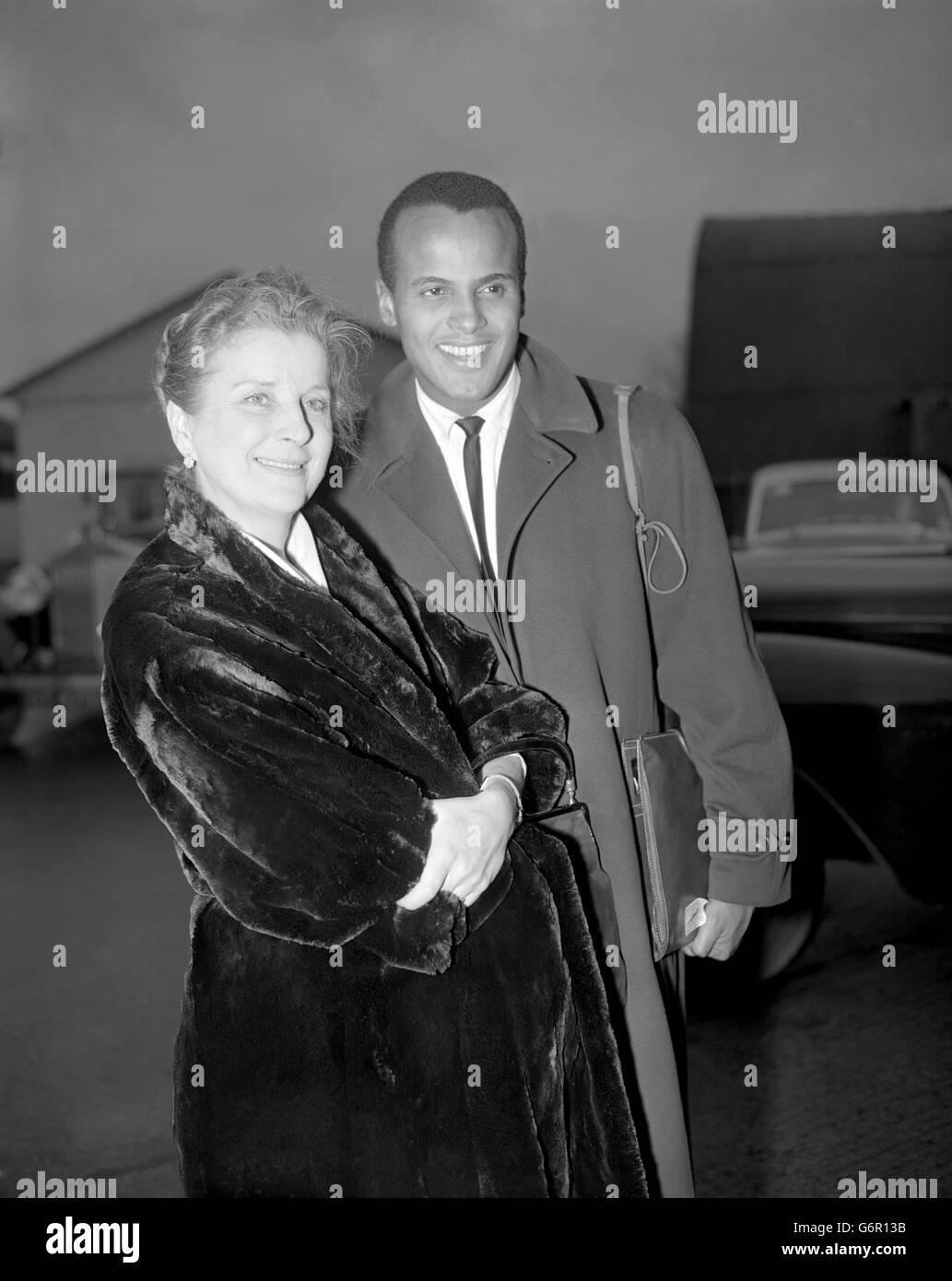 Der Schauspieler Harry Belafonte wird von der britischen Schauspielerin Diana Wynyard bei seiner Ankunft am Flughafen London aus New York begrüßt. Er ist hier, um seine Rolle in Darryl F. Zanucks „Island in the Sun“ nach sieben Wochen Standortarbeit in den Britischen Westindischen Inseln zu vervollständigen. Dies ist Mr.Belafontes erster Besuch in London, und Miss Wynyard - die zu den Stars des Films zählt - dachte, es wäre schön, ihn bei seiner Ankunft zu treffen. Stockfoto