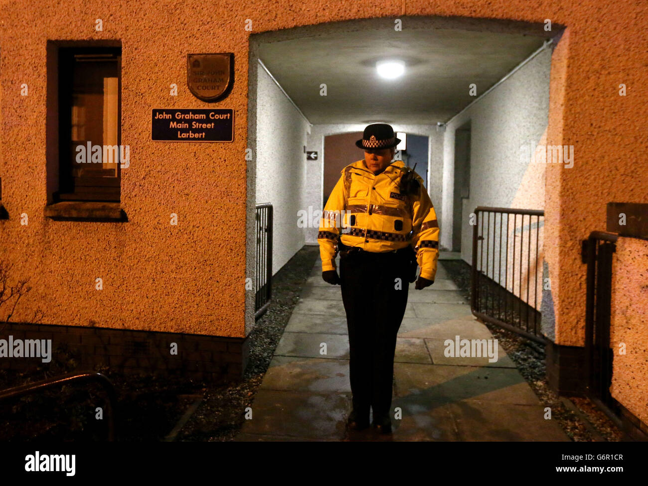 Ein Polizist vor einer ausgebrannten Wohnung, nachdem die Bewohner aus einer geschützten Wohnanlage evakuiert wurden, nachdem in der Wohnung in Larbert bei Falkirk ein großes Feuer ausbrach. Stockfoto