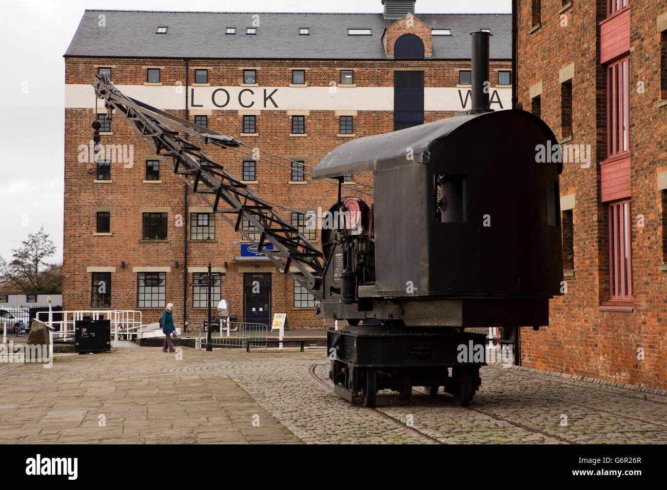 UK, Gloucestershire, Gloucester Docks, alte Dampf angetriebene Kran unter restaurierten Lagerhallen Stockfoto