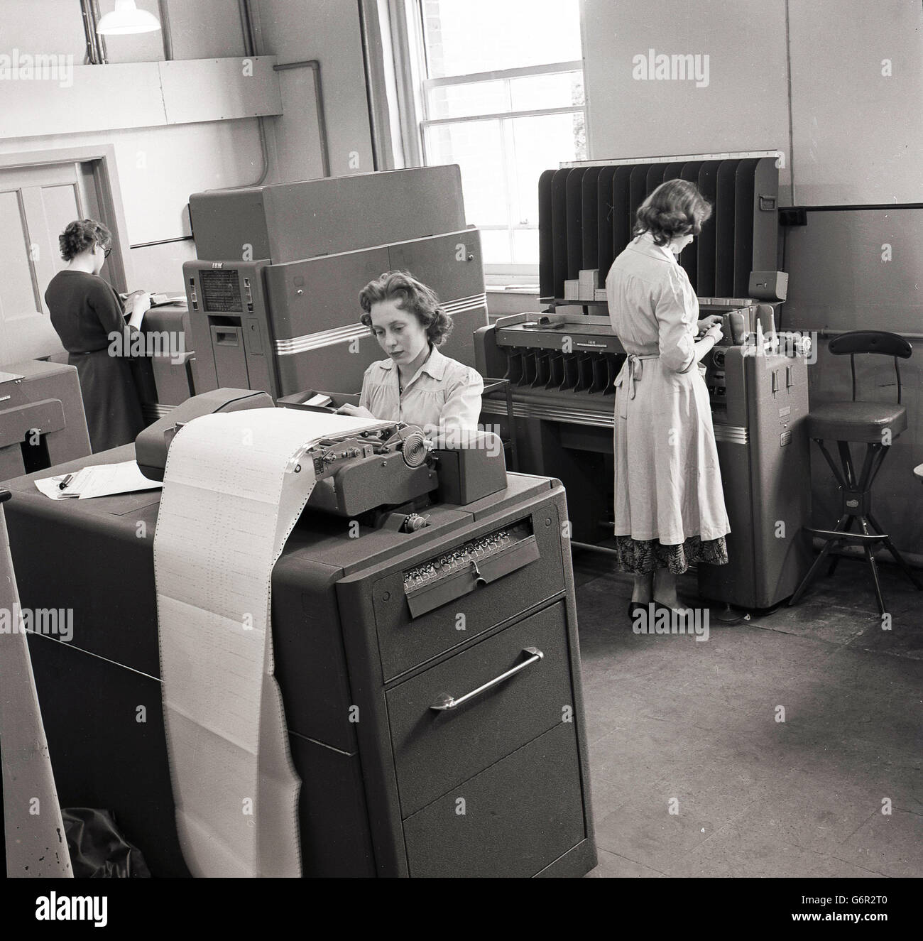 1950er-Jahren, historische, weibliche Arbeitnehmer im Büro mit großen Datenverarbeitung oder Einheit Abrechnungsmaschinen, eine Kombination aus einem großen Schreibmaschine und Rechenmaschine, Wegbereiter der modernen Computer. Stockfoto