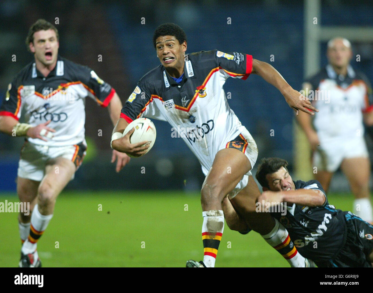 Bradford Bulls Leon Price wird von Penrith Panthers Craig Gower während der World Club Challenge 2004 im Alfred McAlpine Stadion in Huddersfield angegangen. Stockfoto