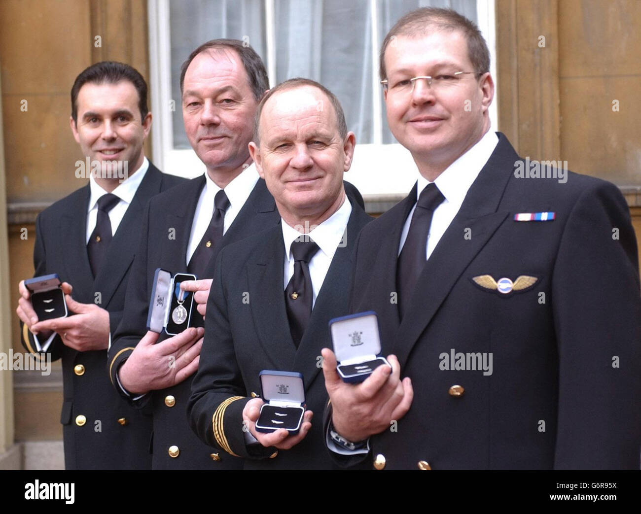 Eine Hubschrauber-Rettungsmannschaft, die ihr eigenes Leben riskierte, um neun Männer zu retten, nachdem ihr Fischtrawler auf hoher See im Atlantik versank, wurde von der Queen im Buckingham Palace in London geehrt. Von links: Capt Neill Stephenson, Chris Murray, Julian Grinney und Clark Broad, Die alle Mitglieder des Küstenwache Rettungshubschraubers in Stornoway sind, zeigen stolz ihre Queen's Gallantry Medal (Murray) und Queen's Commendation for Tapfery in the Air Awards für ihre Rolle bei der Rettung der Besatzung vor einem geplagten deutschen Fischerboot im März 2001. Stockfoto