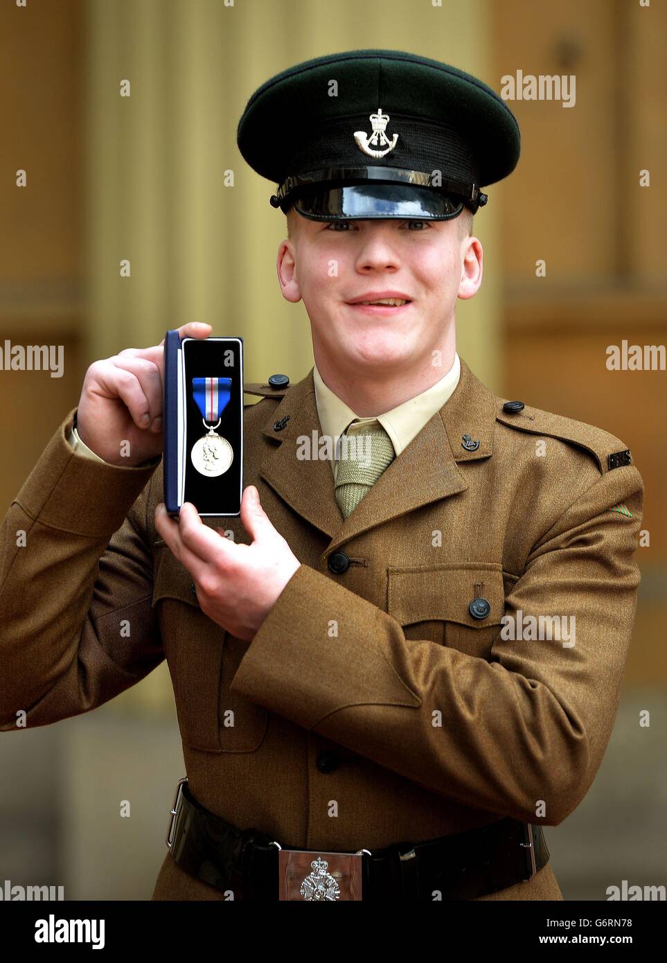 Rifleman Ben Taylor vom Mercian Regiment hält seine QGM (Queen's Gallantry Medal), nachdem sie ihm vom Prince of Wales während einer Investiturzeremonie im Buckingham Palace im Zentrum von London überreicht wurde. Stockfoto