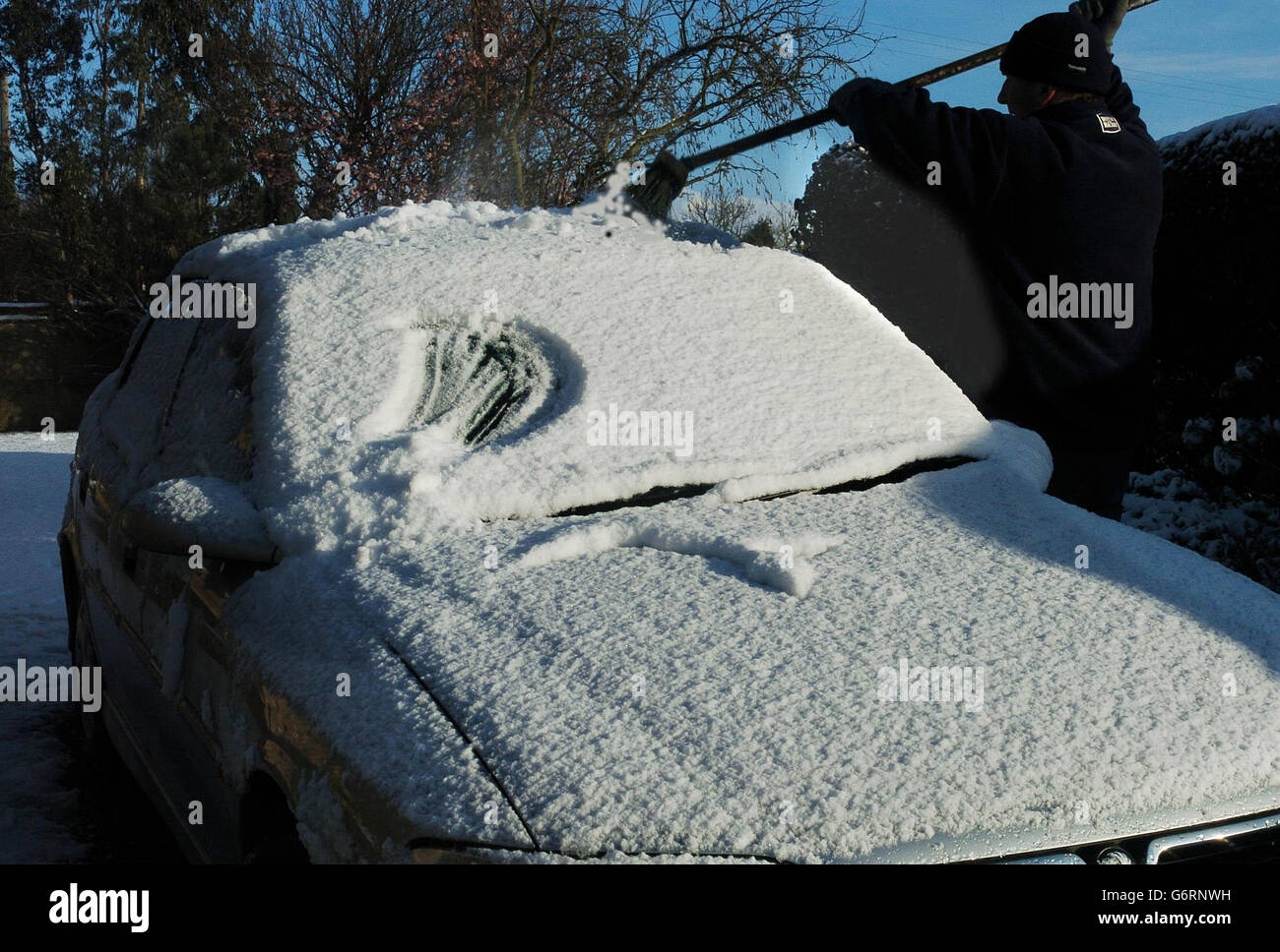 Ein Autofahrer fegt Schnee vom Dach seines Autos in der Nähe von York, während Wetterprognosen vorhersagten, dass die große Kälte anhalten würde. Autofahrer wurden gewarnt, nur bei Bedarf zu fahren, da schwere Schneeschauer Richtung Süden fuhren, die das West Country, East Anglia und Südengland betrafen. Stockfoto