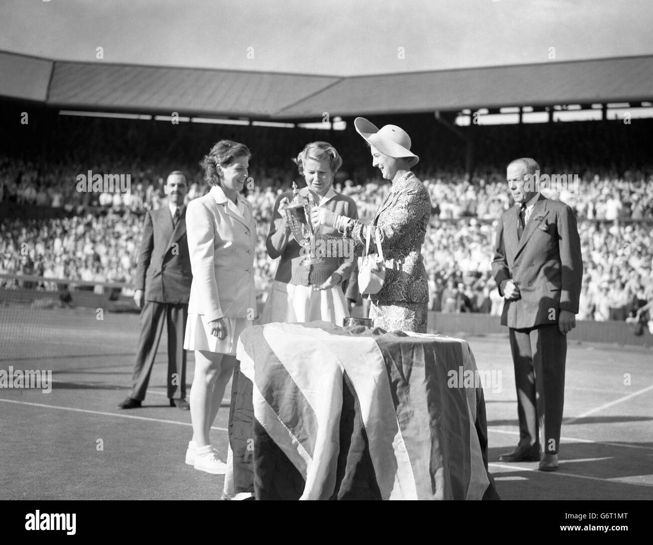 Margaret DuPont (links) und Louise Brough werden von der Herzogin von Kent in Wimbledon mit der Doppel-Meisterschaftsprophäe für Frauen ausgezeichnet. Stockfoto