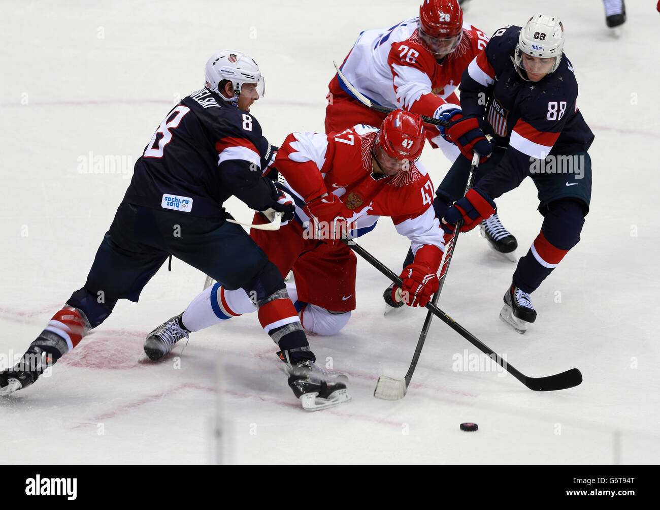 Russlands Alexander Radulov wird von den USA Joe Pavelski (links) und Kane Patrick in ihrem Vorrundenspiel während der Olympischen Spiele in Sotschi 2014 in Krasnaja Poljana, Russland, angegangen. Stockfoto