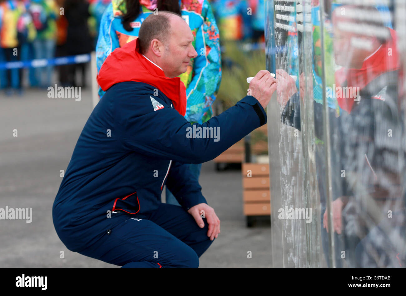 Olympische Winterspiele in Sotschi - Aktivitäten vor den Spielen - Donnerstag. Team GB Chef de Mission Mike Hay unterschreibt im Namen der Athleten die Willkommenswand. Stockfoto