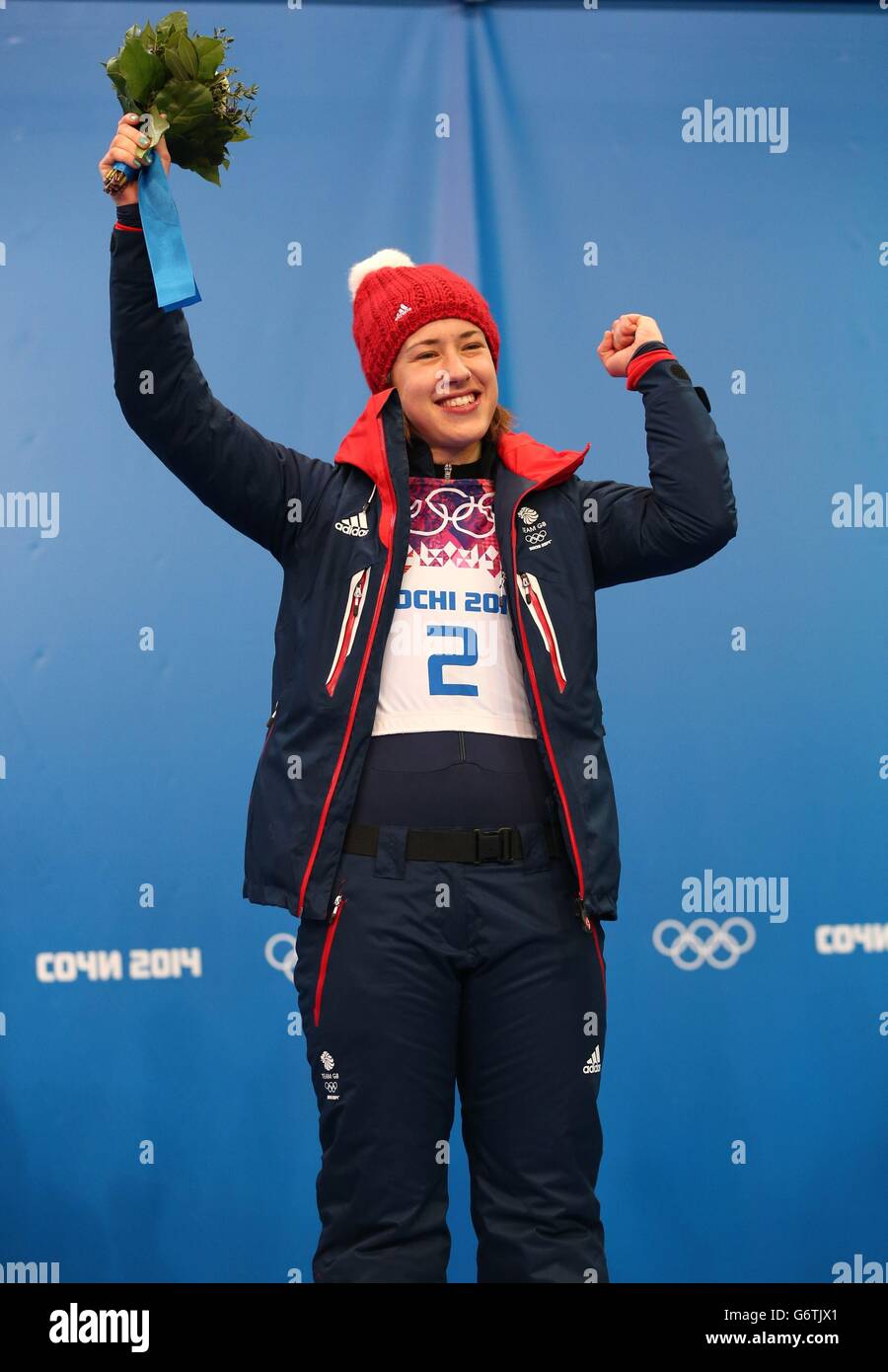 Die britische Lizzy Yarnold reagiert auf das Blumenpodium, nachdem sie während der Olympischen Spiele 2014 in Sotschi in Krasnaya Polyana, Russland, eine Goldmedaille beim Frauen-Skelett-Finale im Sanki Sliding Center gewonnen hat. Stockfoto