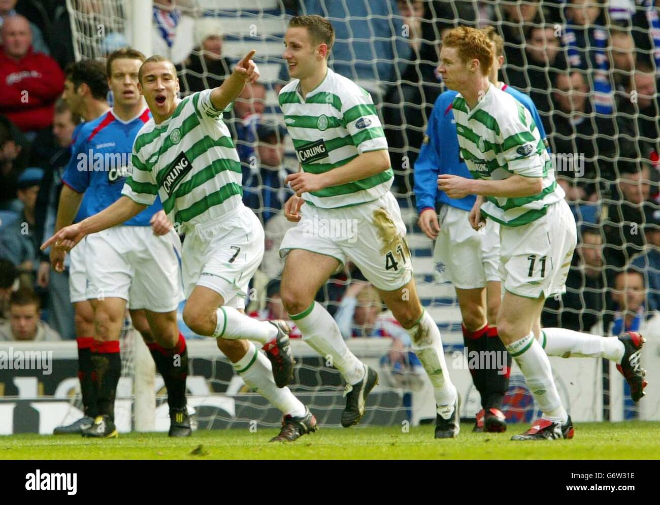 Henrik Larsson von Celtic (links) schiebt sein Tor gegen die Rangers während des Spiels der Scottish Premier League der Bank of Scotland im Ibrox Stadium der Rangers in Glasgow. Stockfoto