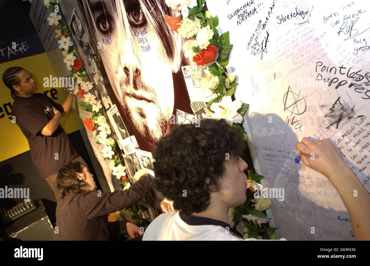 Die Besucher zollen Kurt Cobain - dem amerikanischen Singer-Songwriter der Grunge-Gruppe Nirvana - am Vorabend des Selbstmords des Rockstars am 5. April 1994 in der Virgin Megastore Oxford Street im Zentrum von London ihre Ehre, wo eine riesige 12' x 7' Memorial Wall errichtet wurde, Mit Leerzeichen für Fans, um ihre eigenen Nachrichten zu schreiben. Stockfoto