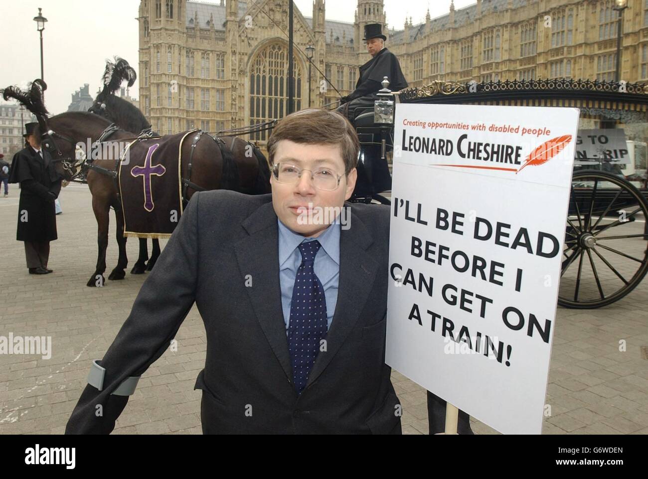 John Knight, der politische Leiter der Behindertenhilfe Leonard Chenshire, protestiert vor einem Pferdewagen auf dem Parliament Square in London. Der Leichenwagen wurde verwendet, um zu unterstreichen, dass das aktuelle Datum für die Entfernung von Zügen, die für Behinderte nicht zugänglich sind, 2035 ist. Zu diesem Zeitpunkt wird geschätzt, dass etwa 58 % der behinderten Menschen, die die Leonard Chenshire Charity nutzen, verstorben sein werden. Stockfoto