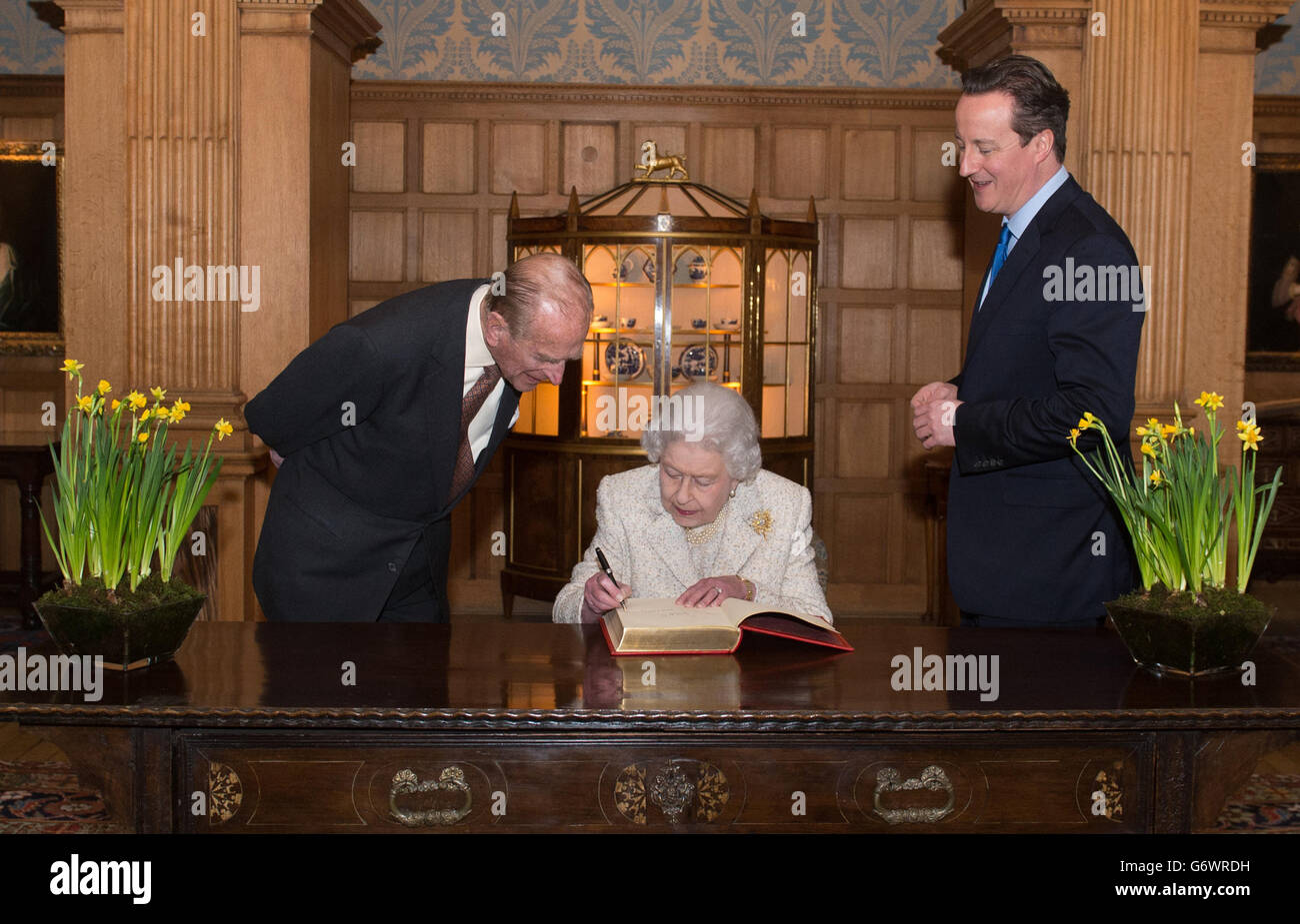 Königin Elizabeth II. Unterschreibt heute im Chequers ein Besucherbuch, wo sie und der Herzog von Edinburgh als Gäste von Premierminister David Cameron und seiner Frau Samantha zu Mittag aßen. Stockfoto