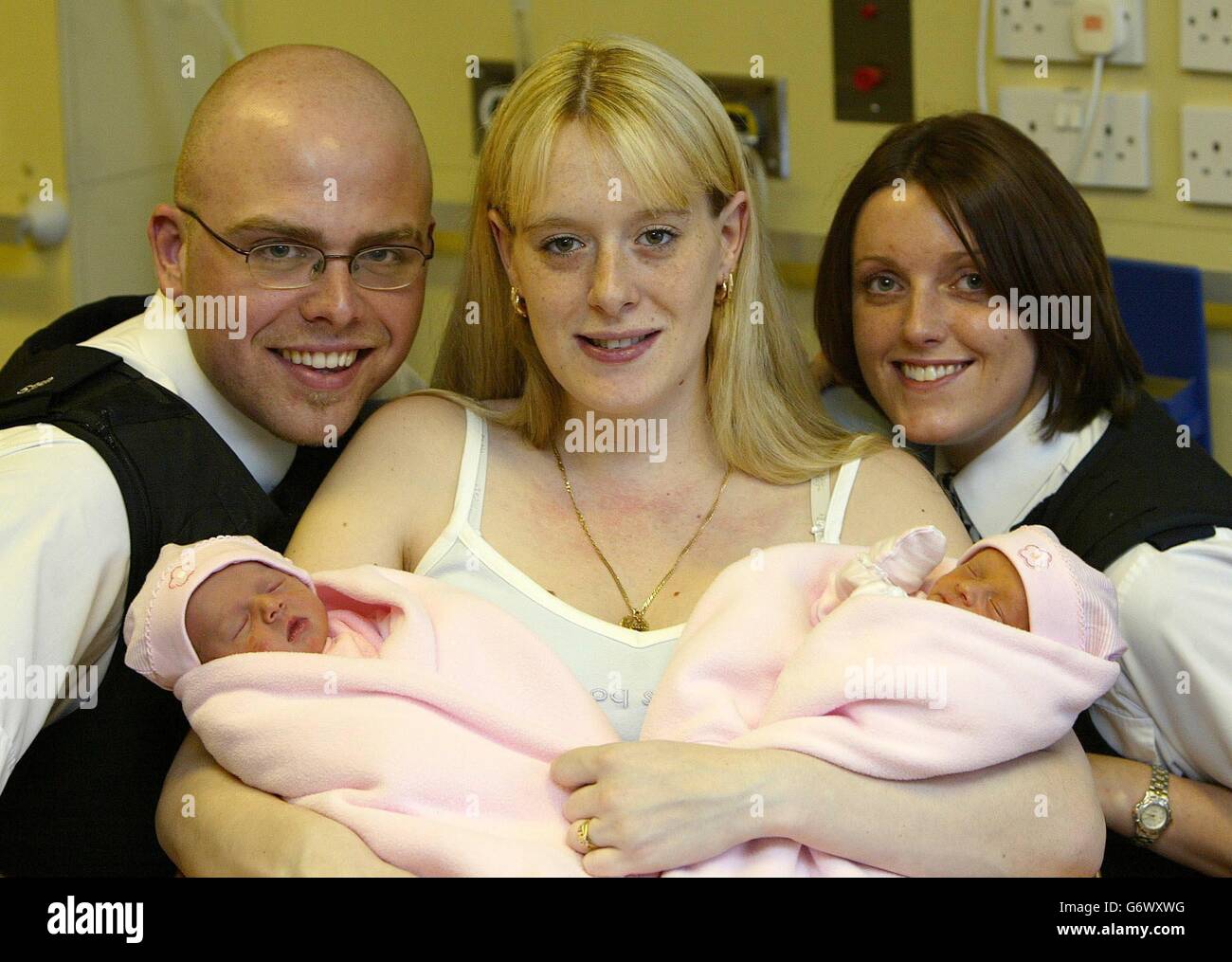 Mutter Neeley Owens mit den Zwillingen Abbie und Ashley und den Polizisten James King und Karen Brownlow im Hope Hospital, Manchester, die bei der Geburt des Babys halfen. Stockfoto