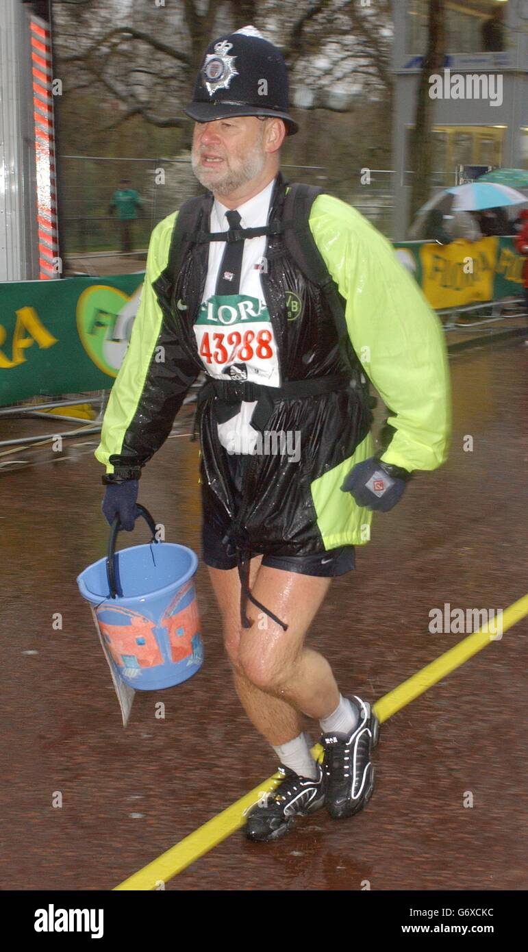 Ein Konkurrent in Polizeiuniform komplettiert den Flora London Marathon Stockfoto