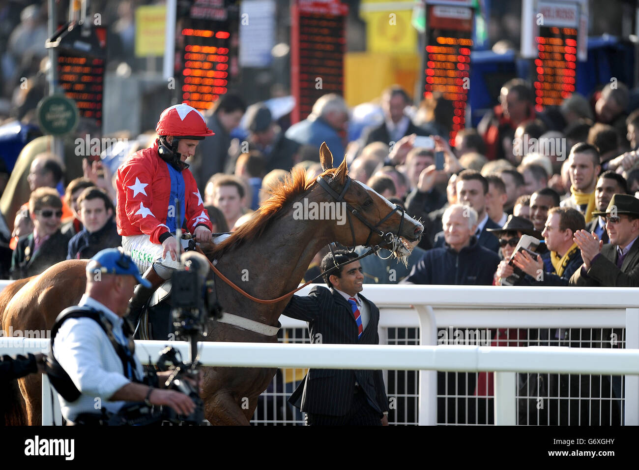 Vater de Grugy und Jockey Jamie Moore nehmen den Applaus entgegen Nach dem Sieg in der BetVictor Queen Mutter Champion Chase Stockfoto