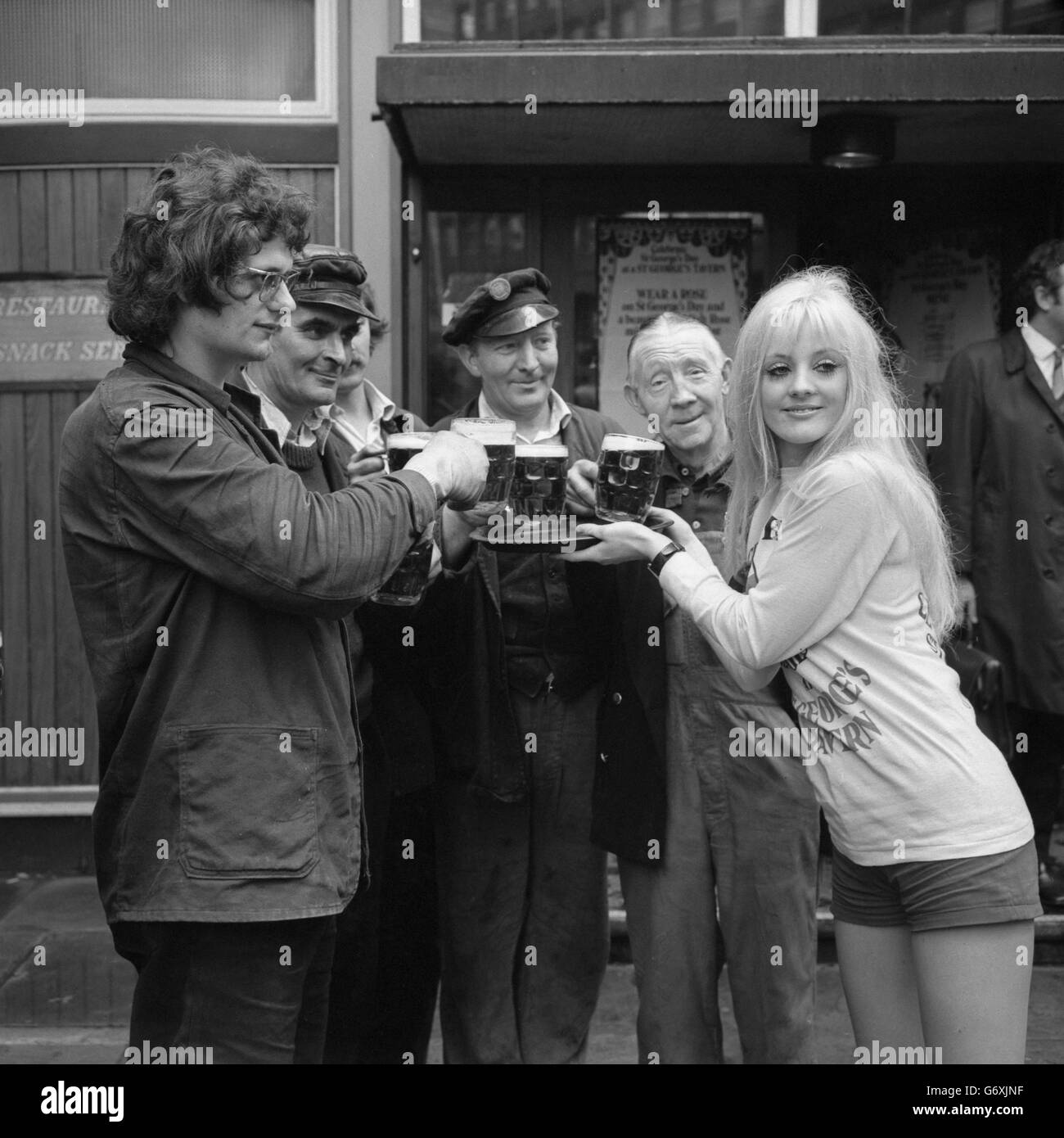 Viki Johnson (r) aus Wimbledon gibt am St. George's Day im Namen von St. George's Tavern's Limited Freibier an Arbeiter außerhalb des Stag in der Allington Street, London, aus. Stockfoto