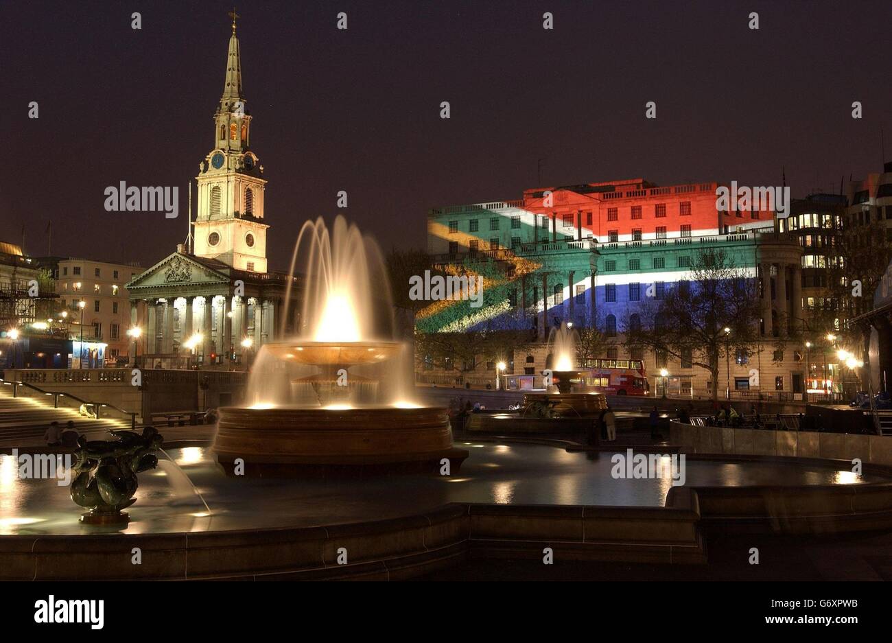 Das Südafrikanische Haus, auf dem Londoner Trafalgar Square, wurde der Ort zahlreicher Anti-Apartheid-Proteste mit den Farben der südafrikanischen Nationalflagge beleuchtet, um ein Jahrzehnt der Demokratie zu feiern. Südafrikas hohe Kommission auf dem Londoner Trafalgar Square war in kräftiges Rot, Grün, Gold, Blau, Schwarz und Weiß getaucht. Die Y-Form, die über die Flagge läuft, symbolisiert die unterschiedlichen Gruppen des Landes, die sich als vereintes Land vorwärts bewegen. Stockfoto