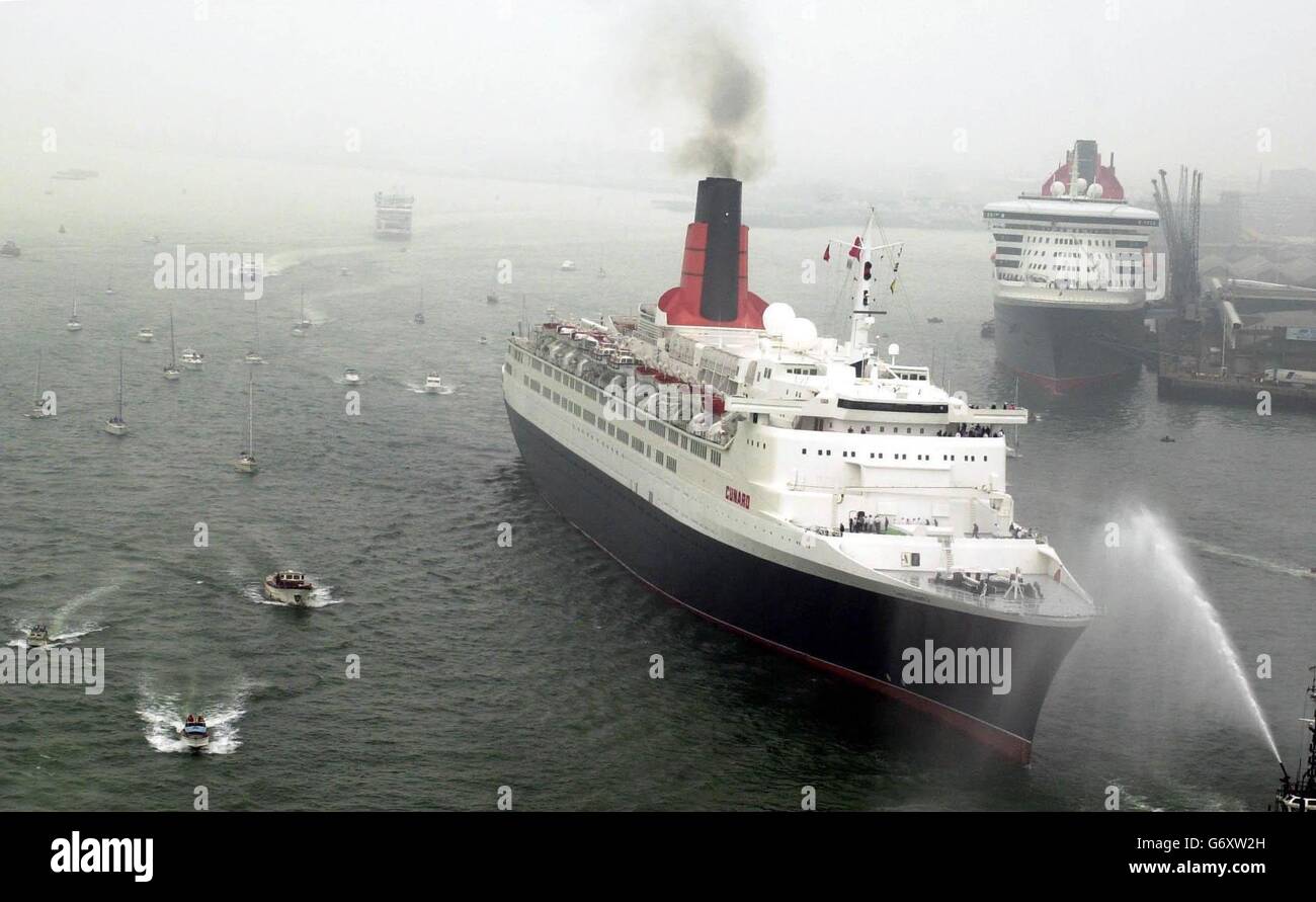 Die QE2 passiert die QM2 in Southampton. Das Ende einer Ära der Kreuzfahrt wurde heute in einer Zeremonie mit der QE2 und Cunards neuem superliner, der 150,000 Tonnen schweren Queen Mary 2 (QM2), markiert. Bei der Zeremonie, an der der stellvertretende Premierminister John Prescott teilnahm, wurde Cunards Flaggschiff-Status von der 35-jährigen QE2 auf die 540 Millionen QM2 übertragen, die offiziell von der Königin im Januar dieses Jahres benannt wurde. Stockfoto