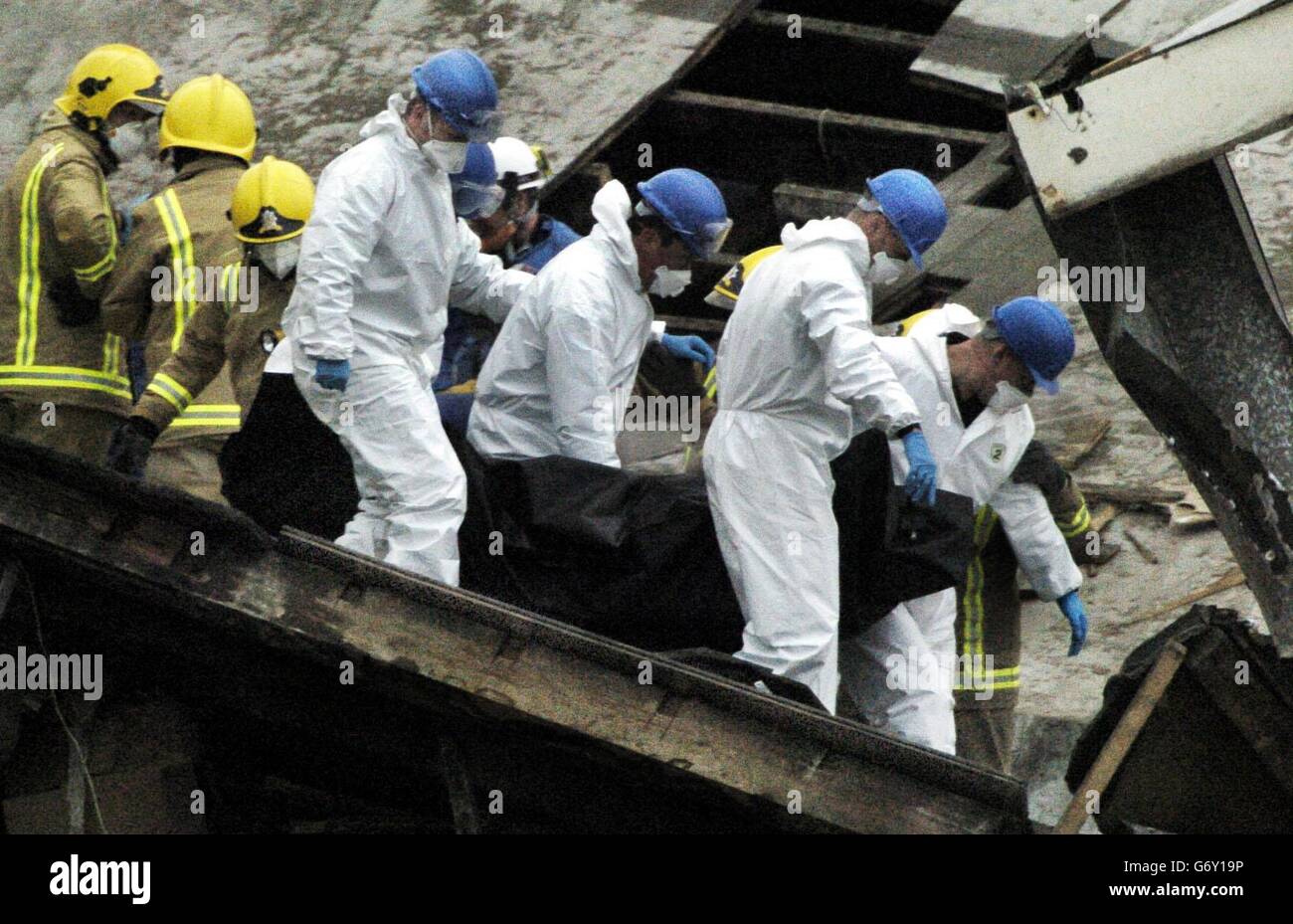 Rettungskräfte tragen einen Leichensack aus dem Wrack eines vierstöckigen Gebäudes in Glasgow, das am Dienstag Mittag nach einer Explosion zusammenbrach. Sieben Menschen wurden als tot bestätigt, und Feuerwehrleute glauben, dass mehr Menschen in den Trümmern des ehemaligen Stockline Plastics Gebäudes gefangen sind. Stockfoto