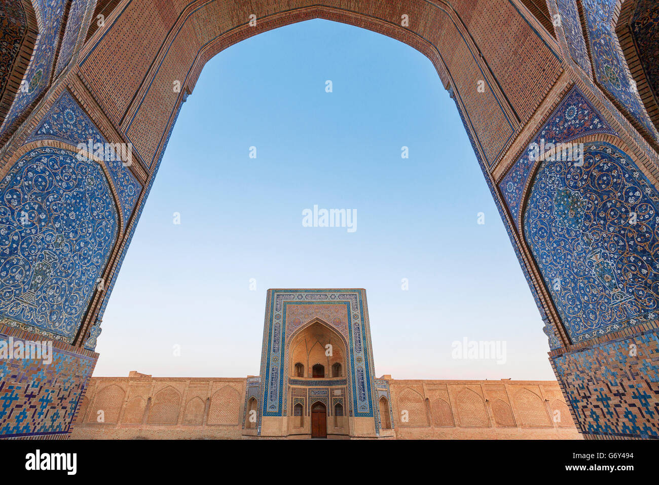 Das Tor der Moschee durch den Bogen des Poi Kalon Madrasah in Buchara, Usbekistan. Stockfoto