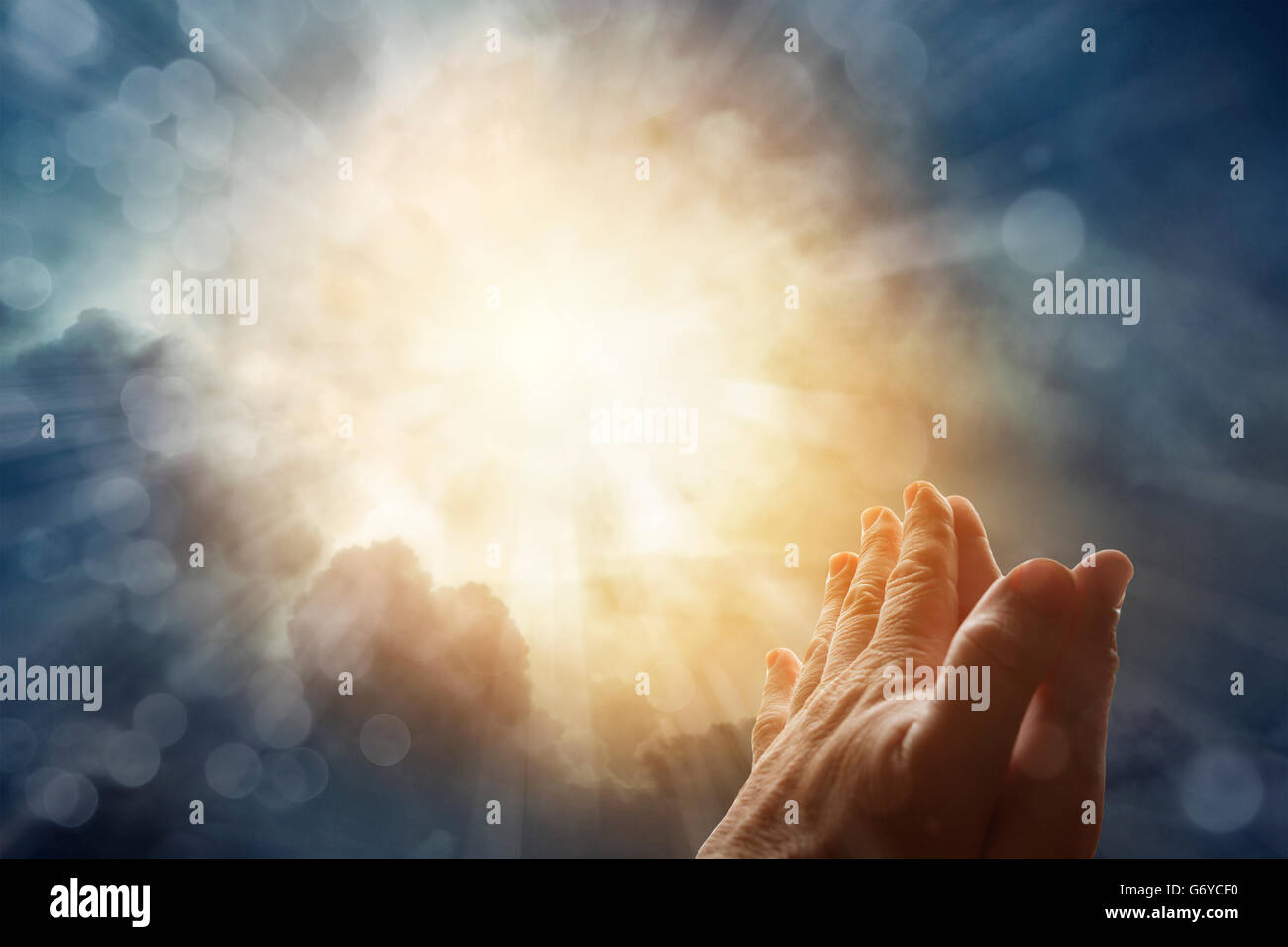 Hände zusammen beten in hellen Himmel Stockfoto