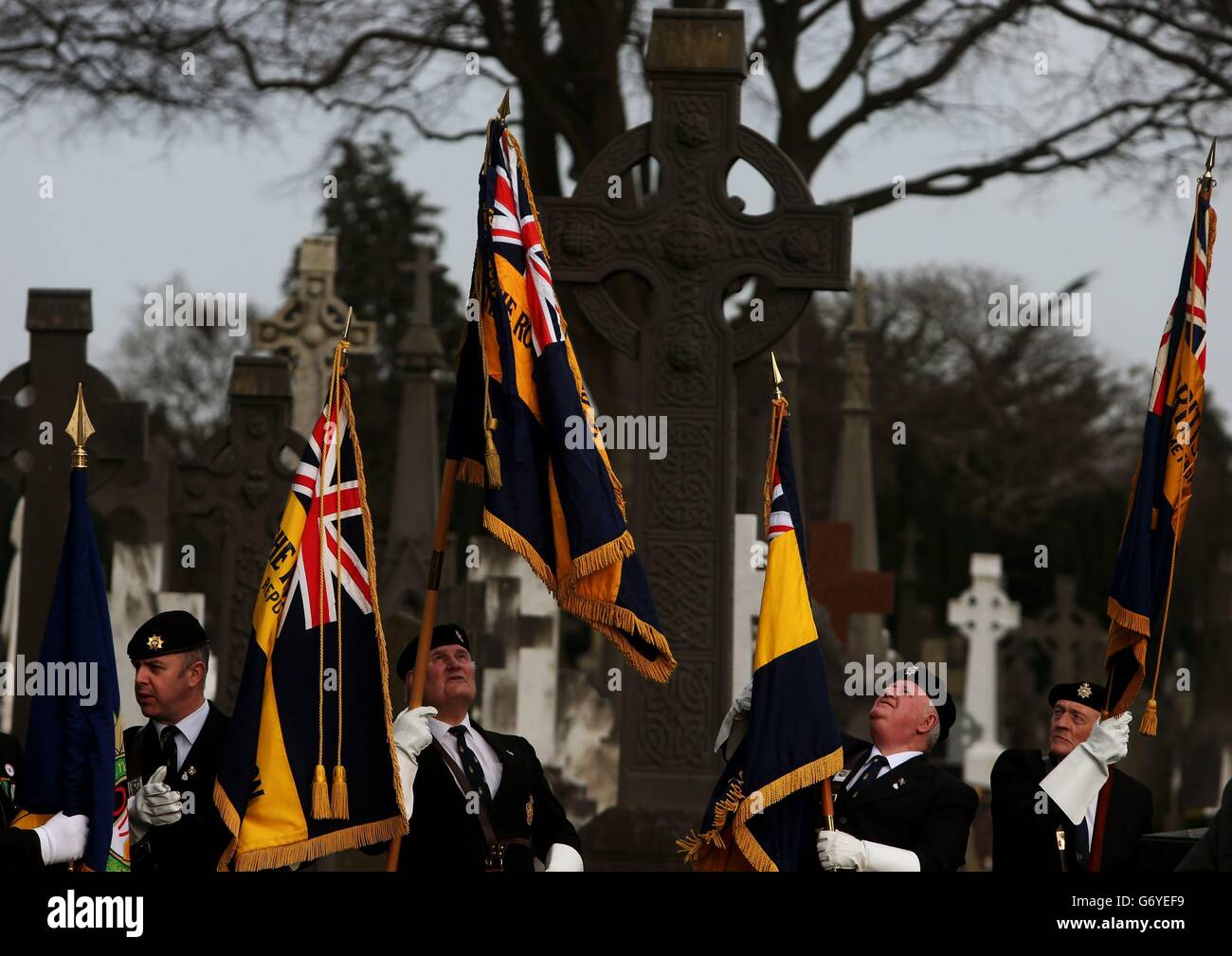 Fahnenträger warten auf den Beginn einer Zeremonie zur Grundsteinlegung für ein monumentales Opferkreuz auf dem Friedhof von Glasnevin in Dublin. Stockfoto