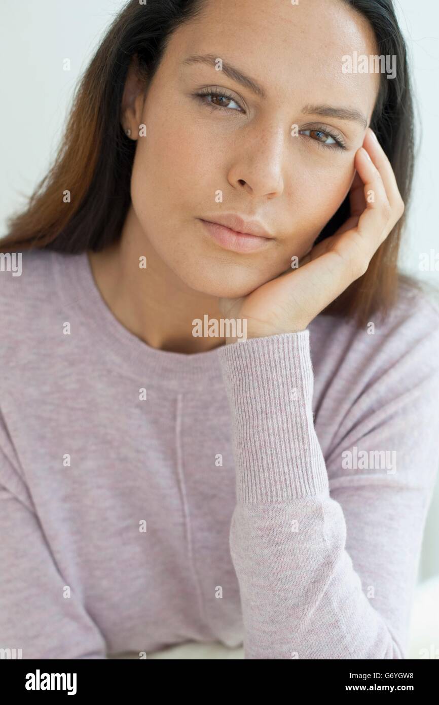 -MODELL VERÖFFENTLICHT. Junge Frau mit der Hand am Kinn, Blick in die Kamera. Stockfoto
