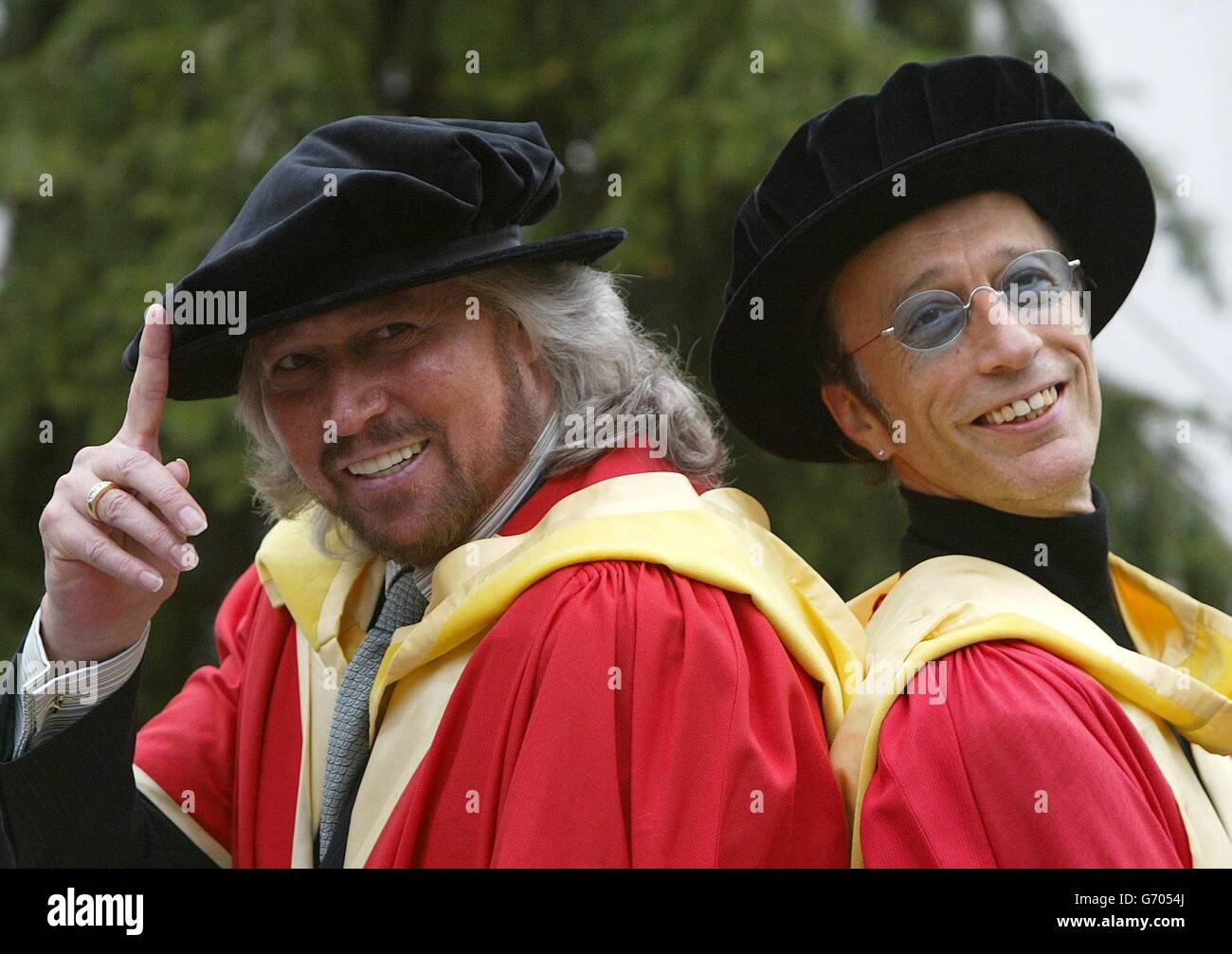 Die Bee Gees, Barry (links) und Robin Gibb posieren für Fotografen, nachdem sie den Ehrendoktortitel (Doktor der Musik) an der Universität von Manchester erhalten haben. Die Brüder nahmen auch einen posthumen Ehrendoktortitel im Namen ihres verstorbenen Bruders Maurice an, der im Januar 2003 starb. Stockfoto
