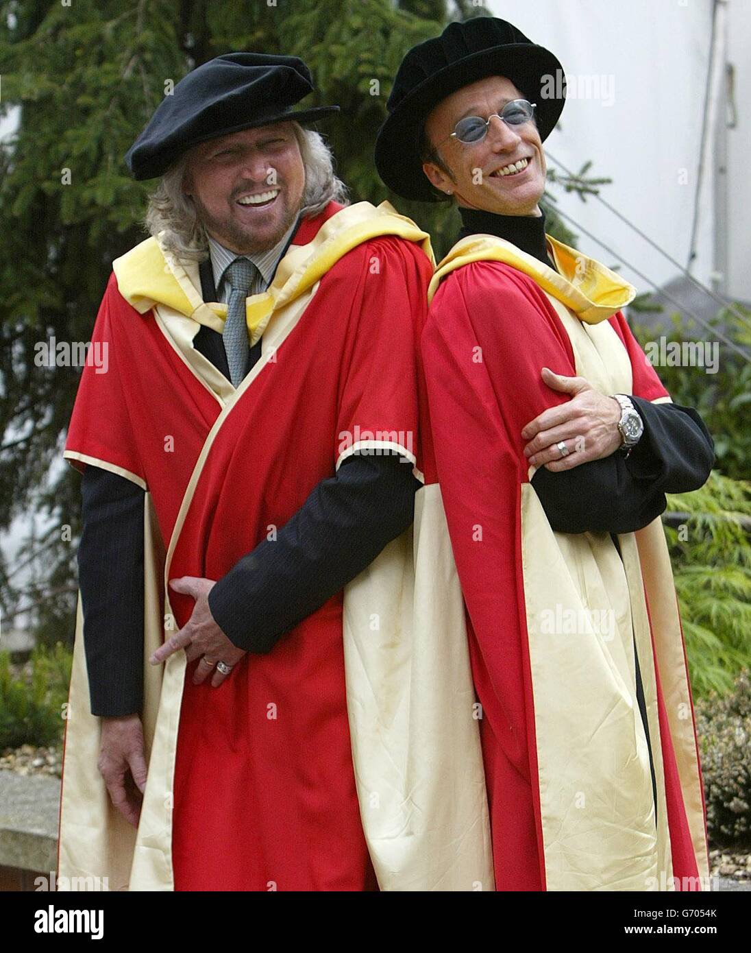 Die Bee Gees, Barry (links) und Robin Gibb posieren für Fotografen, nachdem sie den Ehrendoktortitel (Doktor der Musik) an der Universität von Manchester erhalten haben. Die Brüder nahmen auch einen posthumen Ehrendoktortitel im Namen ihres verstorbenen Bruders Maurice an, der im Januar 2003 starb. Stockfoto