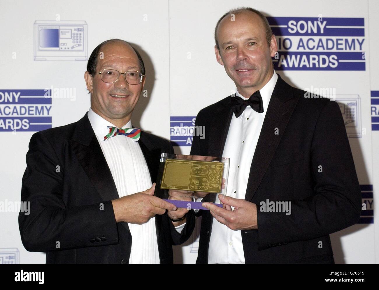 England Rugby-Trainer Clive Woodward (rechts) überreicht Radio 5 Live-Kommentator Ian Robertson mit dem 2003 Award während der Sony Radio Academy Awards 2004, die im Grosvenor House Hotel in der Park Lane, London, stattfinden. Bei der Zeremonie verloren Jonathan Ross und Chris Moyles von Radio 1 gegen Christian O'Connell von XFM, der zum DJ des Jahres ernannt wurde. Stockfoto