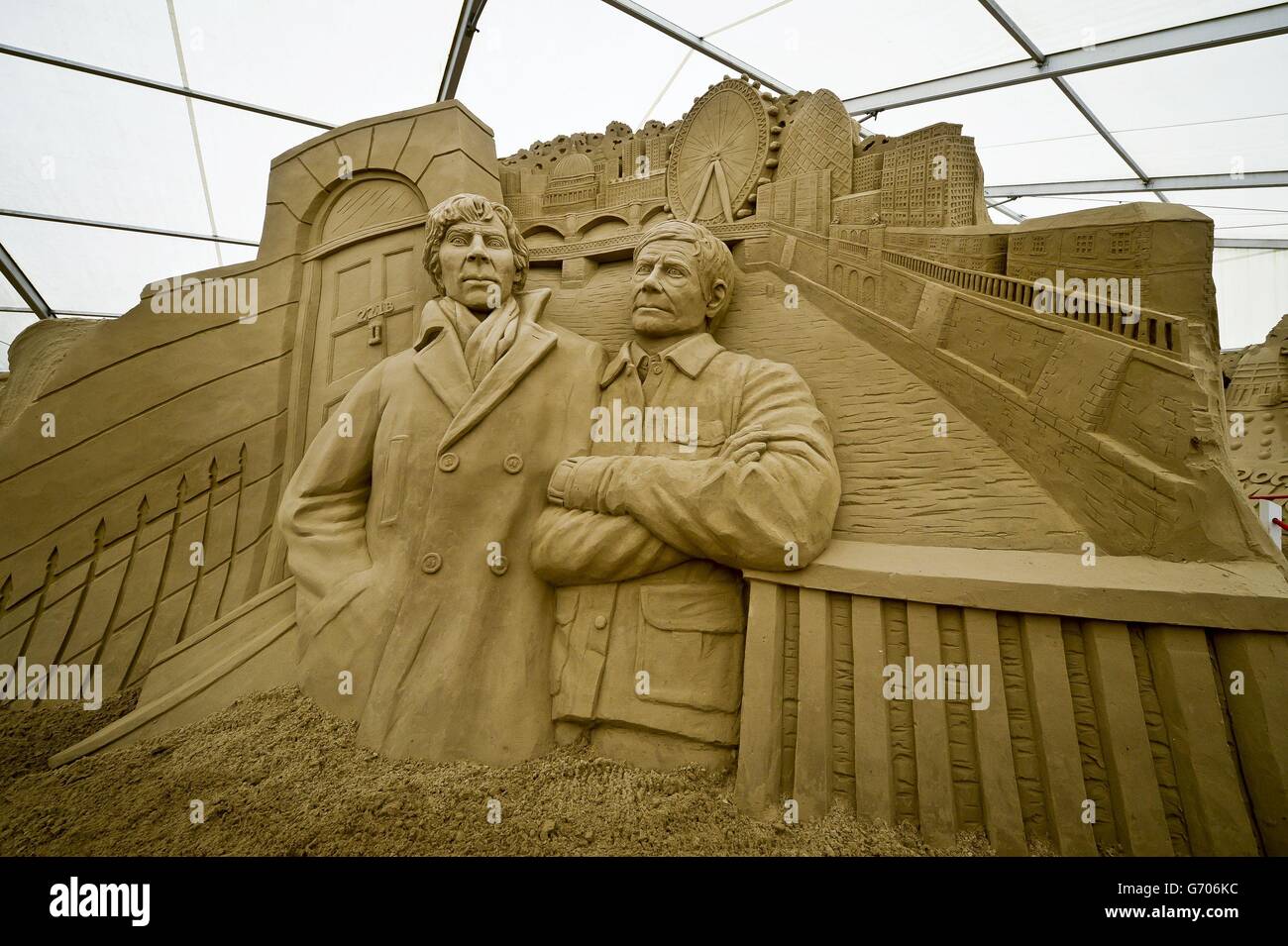 Eine massive Skulptur der Hauptfiguren aus der Fernsehserie Sherlock mit einer Londoner Skyline in Sandworld in Weymouth, wo die Attraktion am Meer für die britische Sommersaison am Samstag, den 5. April 2014, für die breite Öffentlichkeit zugänglich sein wird. Stockfoto