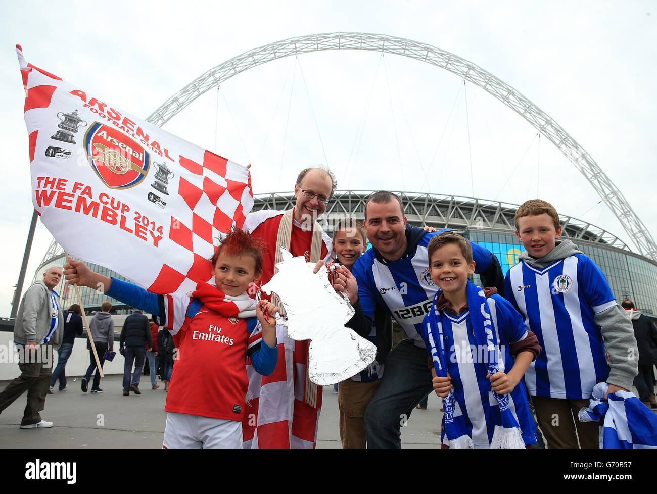 Die Arsenal-Fans Jon und sein Sohn Kerith (links) und die Wigan-Fans Mark, Jack, Harry und Euan posieren vor dem Anstoß für ein Foto vor dem Wembley-Bogen Stockfoto