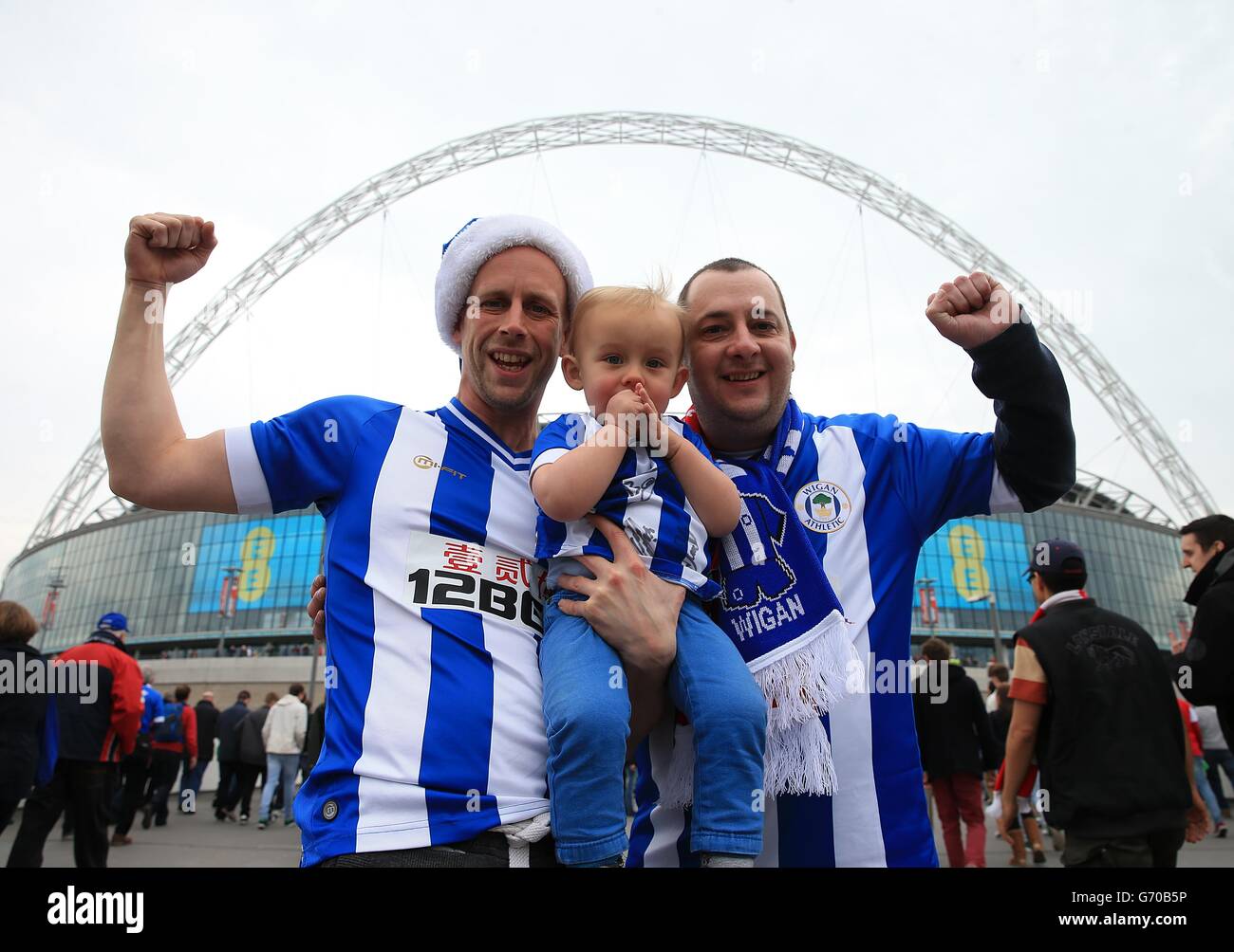 Die Wigan Athletic Fans Chris Wilding, Noah Wilding und Simon Evans von Leyland posieren vor dem Start für ein Foto vor dem Wembley-Bogen Stockfoto