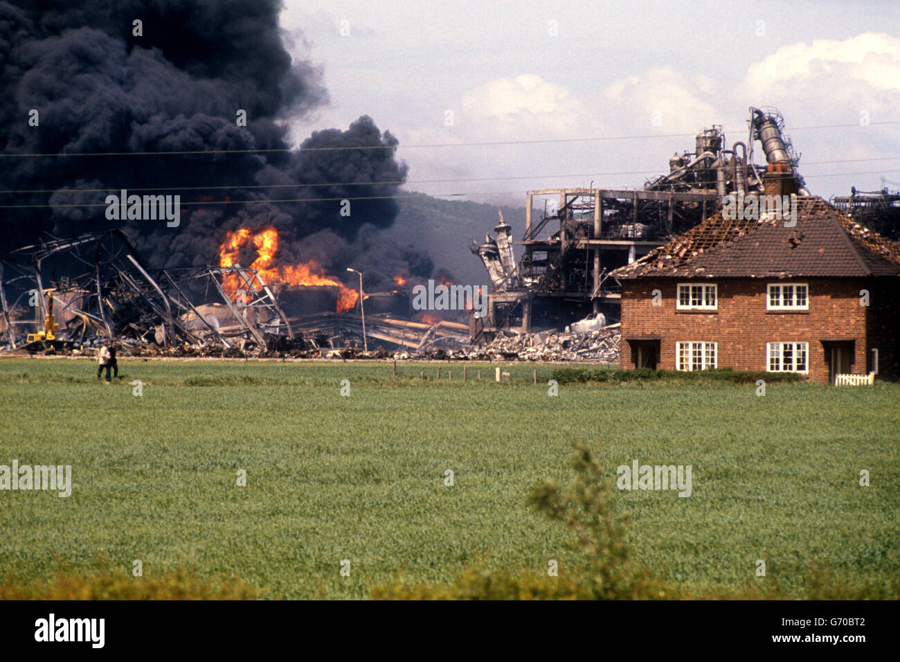Beschädigte Häuser in der Nähe der riesigen Rauch- und Flammensäule der verwüsteten Fabrik im Chemiewerk Nypro UK in Flixborough, North Lincolnshire. Stockfoto