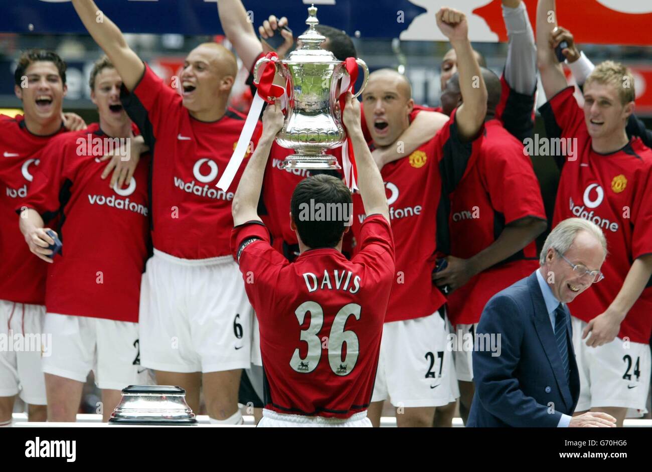 Manchester United Spieler unter Roy Keane (Mitte) feiern den Sieg über Millwall 3-0 im FA Cup Finale im Millennium Stadium, Cardiff. Für die Cup-Präsentation trugen die Vereinigten Spieler T-Shirts mit 'Davis 36' in Erinnerung an Jimmy Davis, ihren Teamkollegen, der im vergangenen August bei einem Verkehrsunfall ums Leben kam. Stockfoto