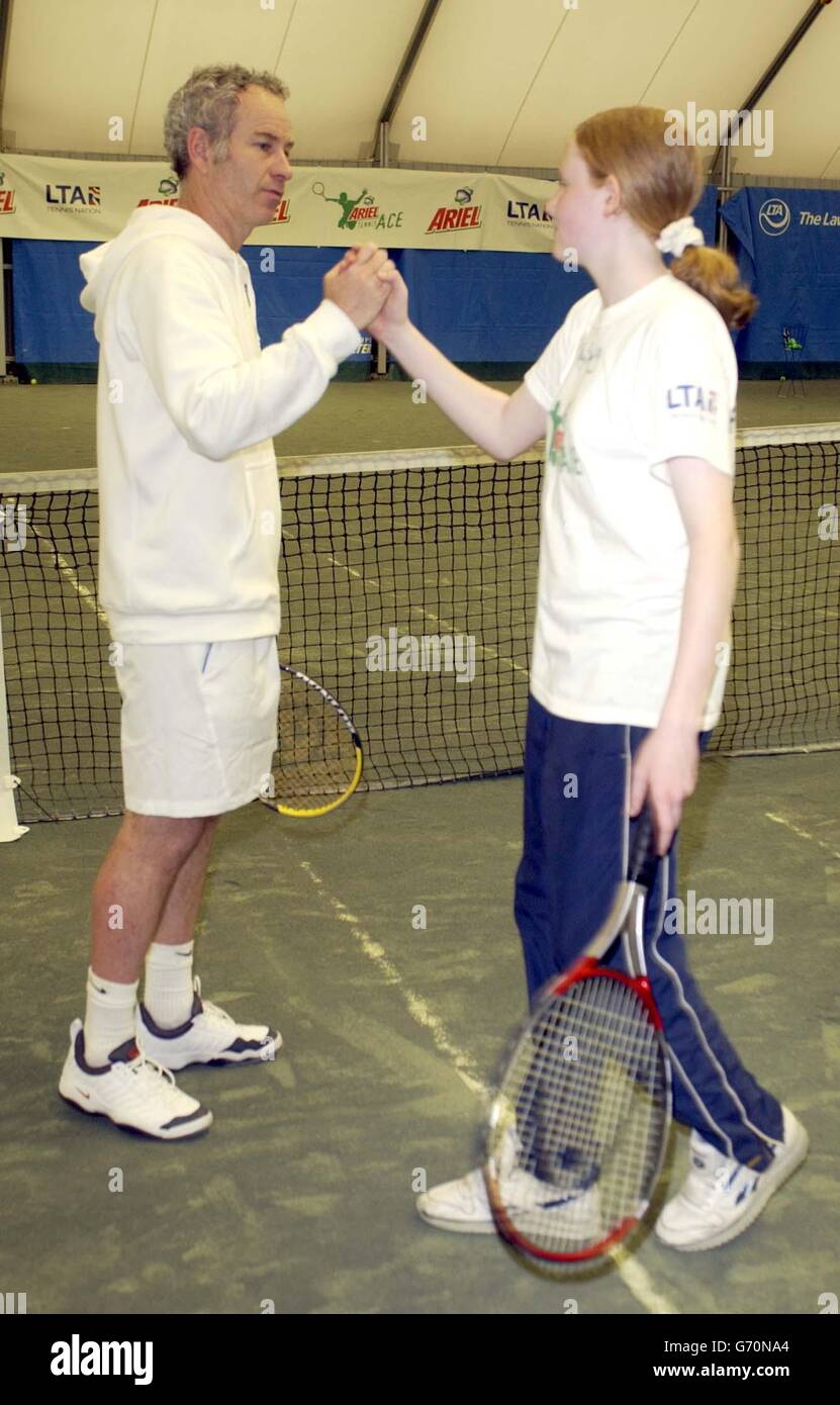Tennis-Legende John McEnroe dient ein Champion und hilft Ariel Tennis Ace Elizabeth Hall, aus Newcastle, machen Sie sich bereit, die große Berühmtheit Wimbledon Finale am 14. Juni, in Lawn Tennis Association Academy. Stockfoto