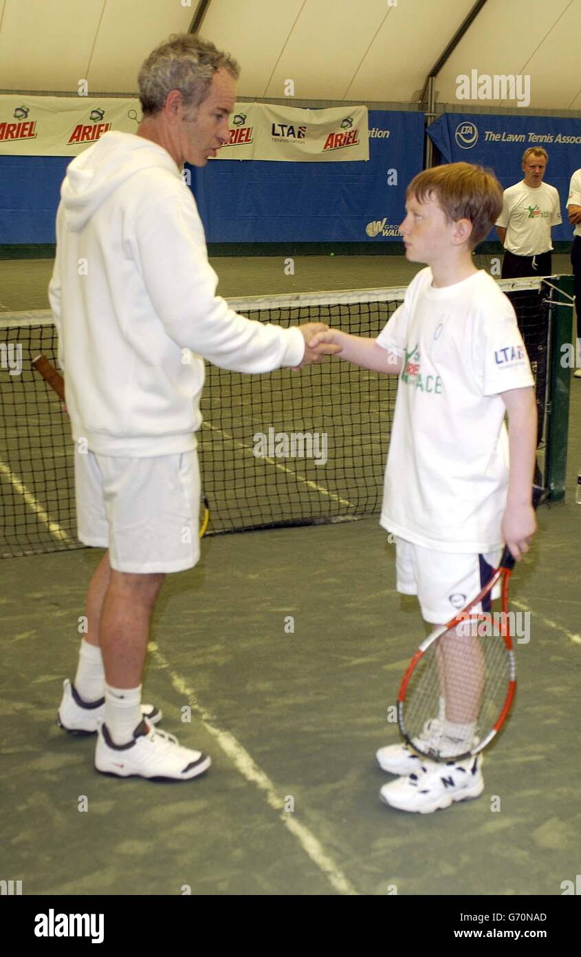 Tennislegende John McEnroe gibt sich einen Champion und hilft Ariel Tennis Ace Garry Smith aus Glasgow, die großen Berühmtheiten Wimbledon Finale am 14. Juni, in Lawn Tennis Association Academy vorzubereiten. Stockfoto