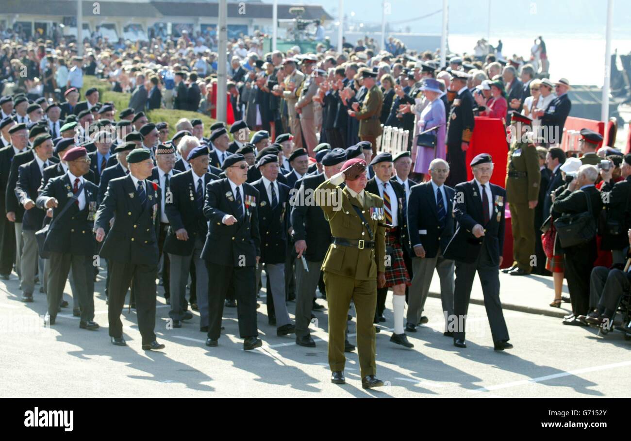 Die britische Königin Elizabeth II. Sieht zu, wie die Veteranen des D-Day im Rahmen des 60. Jahrestages der Landung in der Normandie auf dem Platz in Arromanches, Frankreich, marschieren. Stockfoto