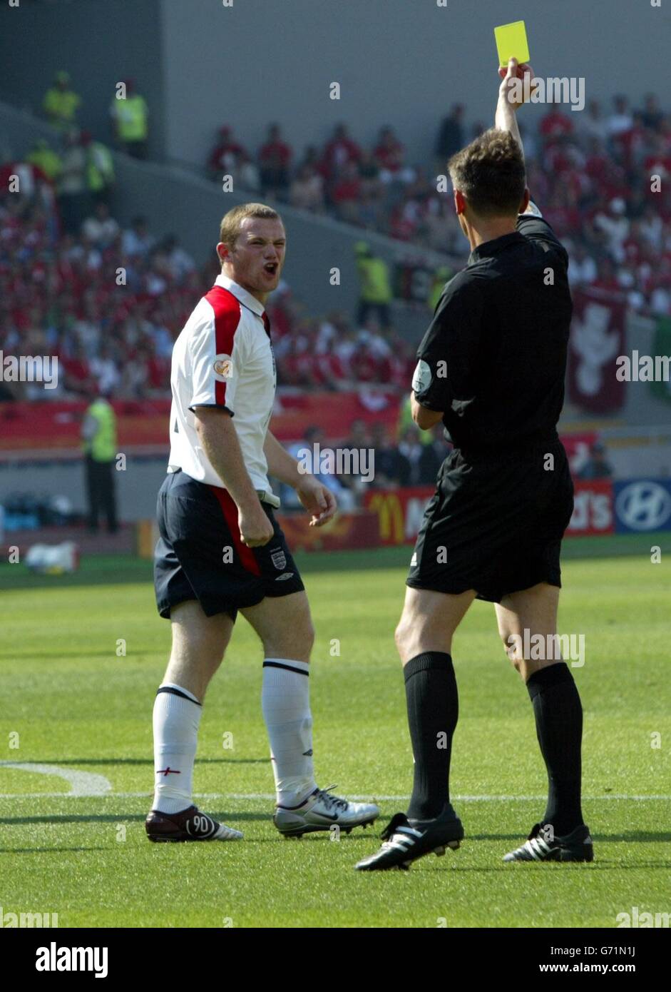 Der englische Wayne Rooney erhält nach seiner Herausforderung auf den Schweizer Torwart beim Euro 2004, der ersten Runde, dem Spiel der Gruppe B bei der Cidade de Coimbra, Portugal, eine gelbe Karte. KEIN HANDY ODER PDA. INTERNETNUTZUNG NUR AUF VON DER UEFA AUTORISIERTEN WEBSITES UND DANN KÖNNEN NICHT MEHR ALS 10 FOTOS PRO HÄLFTE DER NORMALEN SPIELZEIT UND FÜNF FOTOS PRO HÄLFTE DER ZUSÄTZLICHEN ZEIT ÜBER DAS INTERNET MIT EINEM INTERVALL VON MINDESTENS EINER MINUTE ZWISCHEN DER VERÖFFENTLICHUNG JEDES SOLCHEN FOTOS VERÖFFENTLICHT WERDEN. Stockfoto