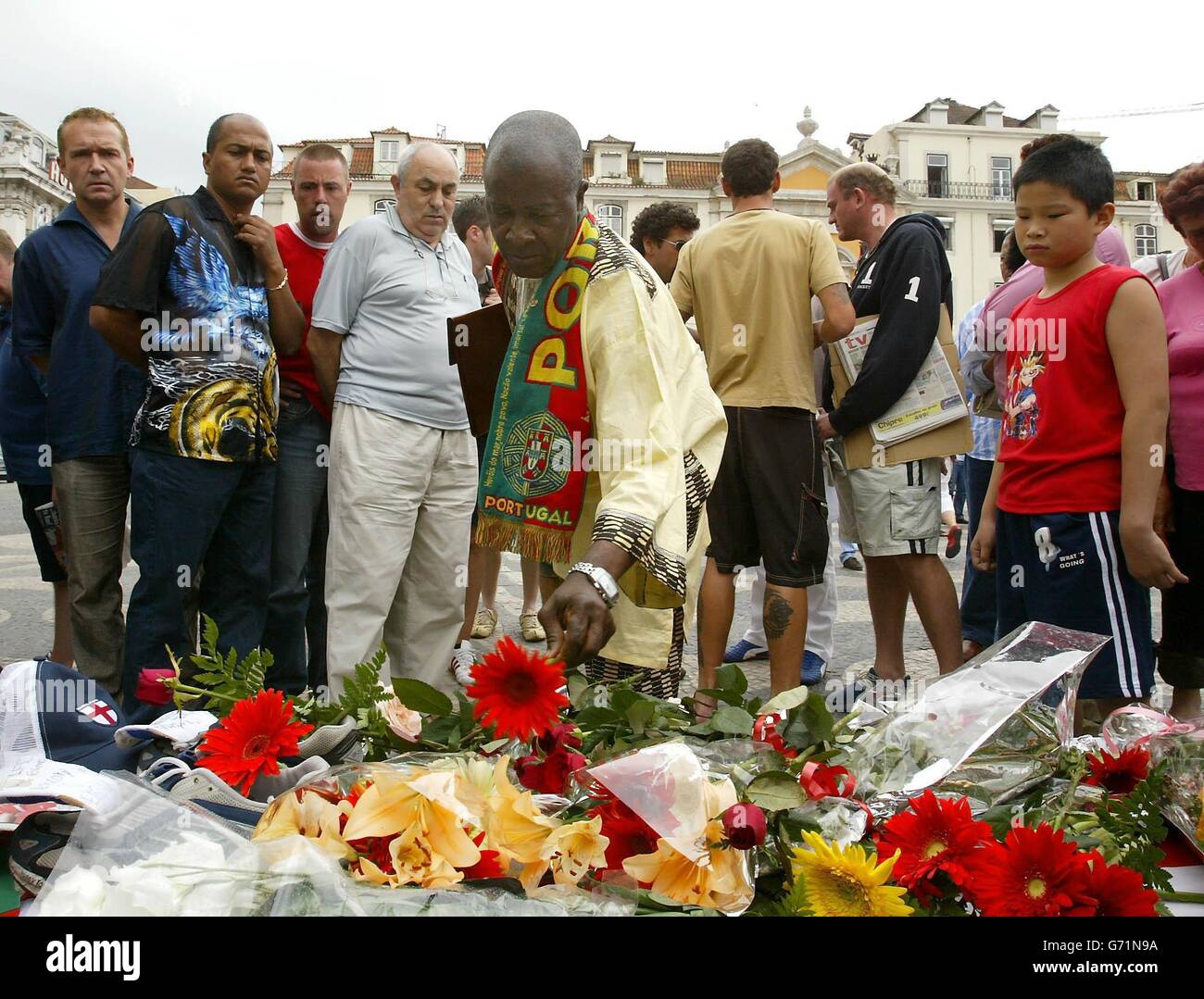 Fußballfans, Brunner und Trauernde legen Blumen an einem Schrein auf dem Rossio-Platz in Lissabon für Stephen Smith, 28, aus Wolverhampton, der während der Feierlichkeiten nach dem Euro-2004-Sieg über Kroatien erstochen wurde. Ukrainische Taschendieb Vadym Abramov, 31, wurde verhaftet und erschien heute vor Gericht. Die Tragödie ereignete sich um 3.30 Uhr in der Rua Augusta, gleich neben dem Rossio-Hauptplatz der portugiesischen Hauptstadt. Stockfoto