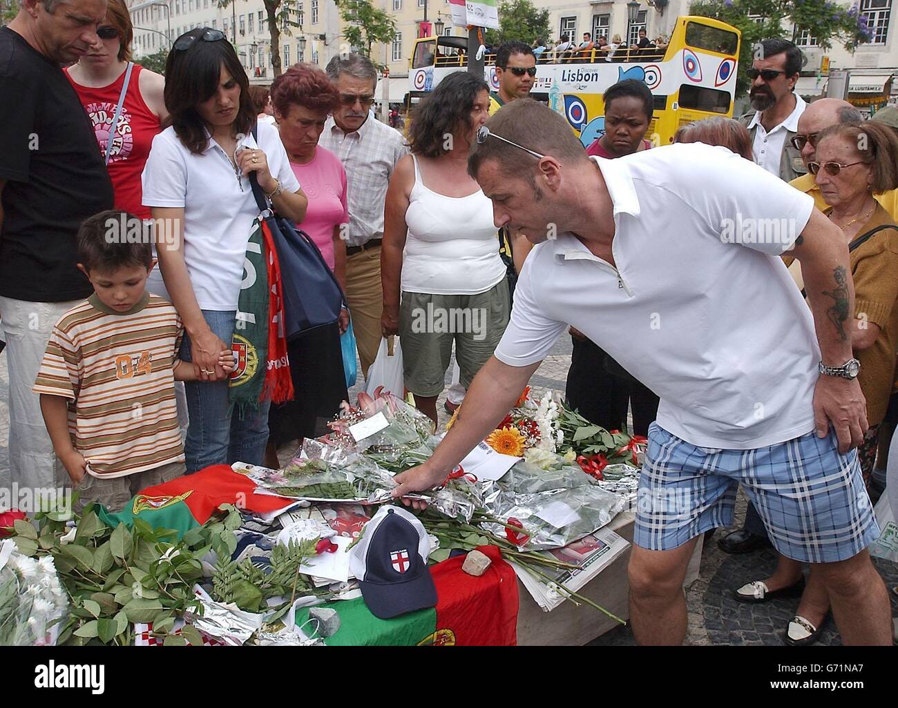 Fußballfans, Brunner und Trauernde legen Blumen an einem Schrein auf dem Rossio-Platz in Lissabon für Stephen Smith, 28, aus Wolverhampton, der während der Feierlichkeiten nach dem Euro-2004-Sieg über Kroatien erstochen wurde. Ukrainische Taschendieb Vadym Abramov, 31, wurde verhaftet und erschien heute vor Gericht. Die Tragödie ereignete sich um 3.30 Uhr in der Rua Augusta, gleich neben dem Rossio-Hauptplatz der portugiesischen Hauptstadt. Stockfoto